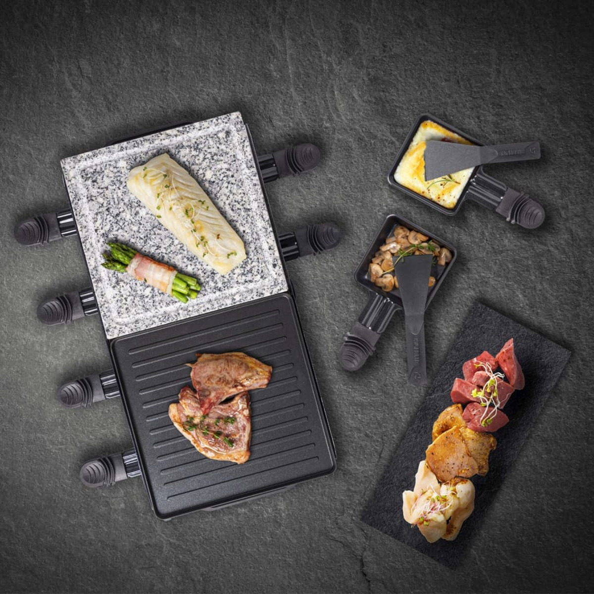 Grill do raclette z różnymi potrawami: rybą, szparagami, mięsem, grzybami i serem.