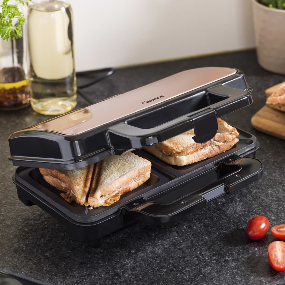 Toster do kanapek z dwoma kanapkami w środku, na białym tle.