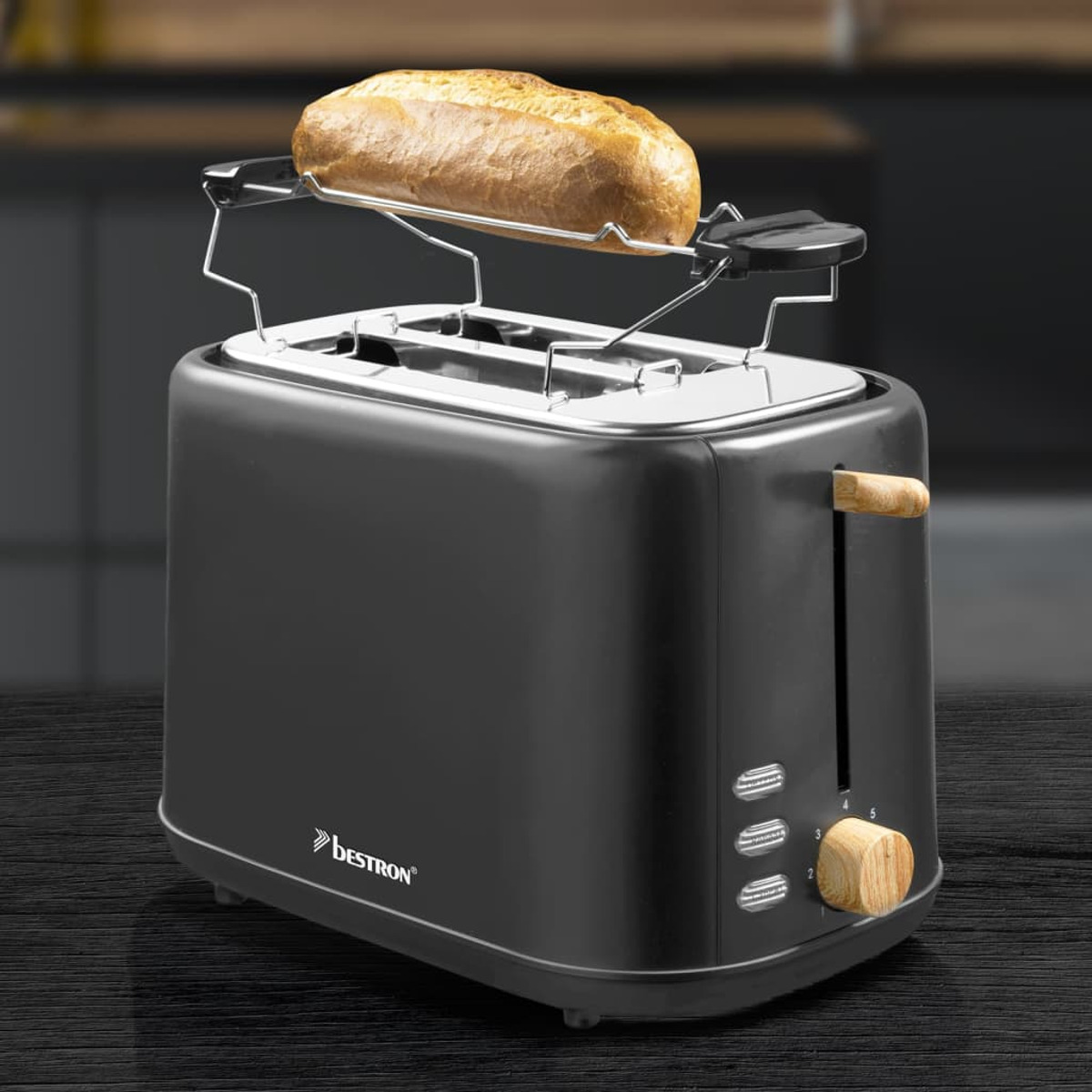 Ein schwarzer Toaster mit Holzgriff, der Brot vor verschwommenem Küchenhintergrund toastet.