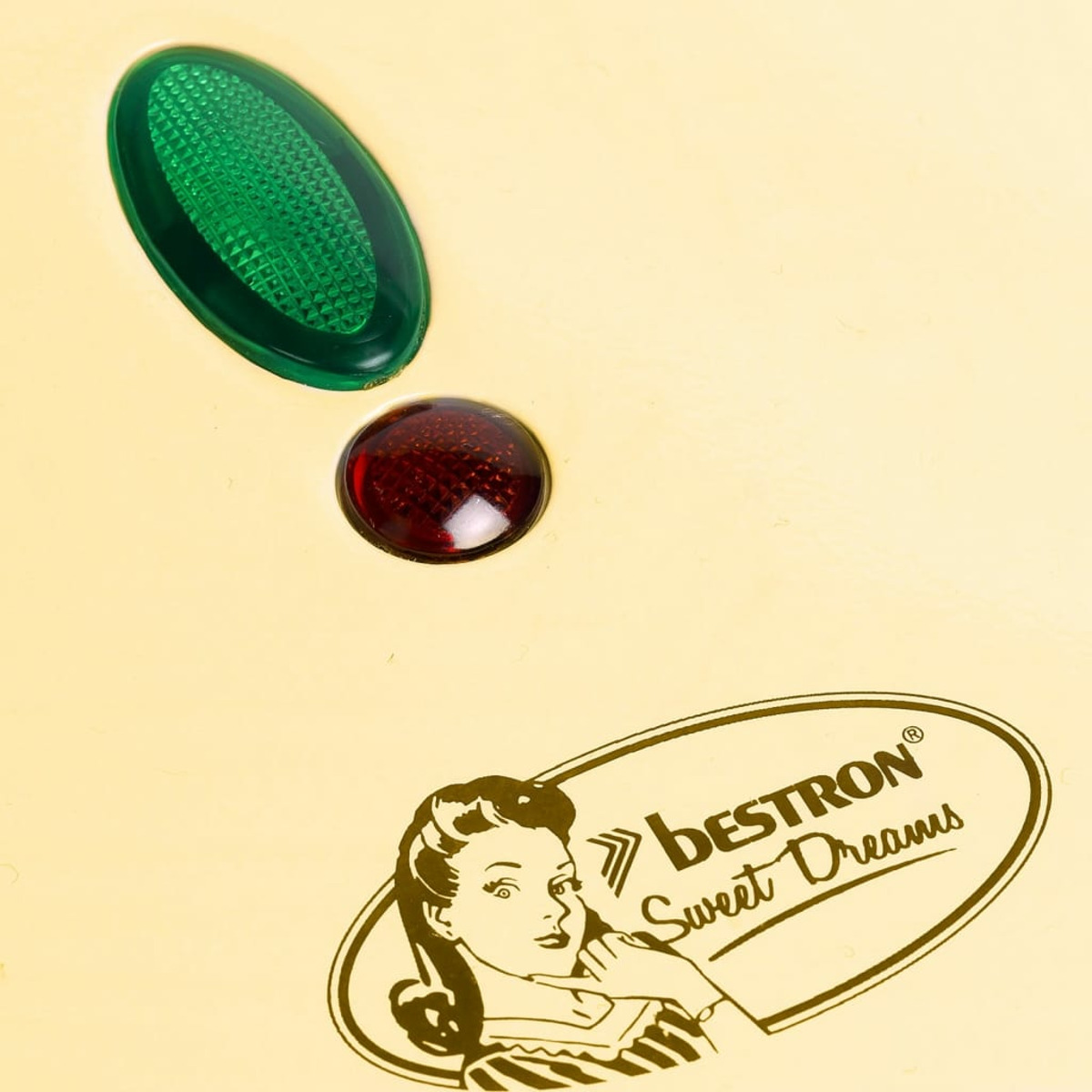 Zbliżenie kremowej powierzchni z logo Bestron i światłami. Na logo widnieje kobieta.