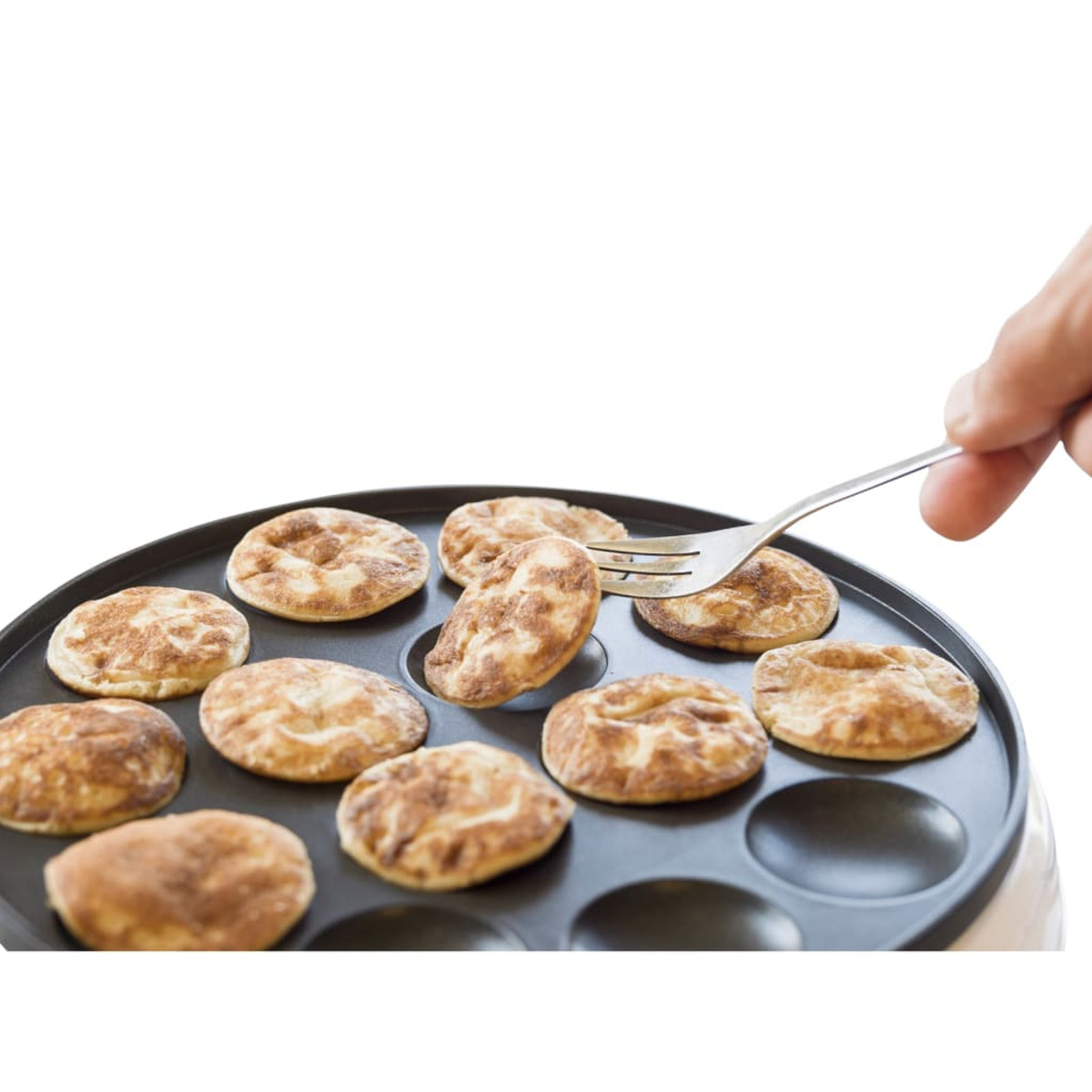 Osoba używająca widelca do przewracania małego naleśnika na okrągłej patelni.