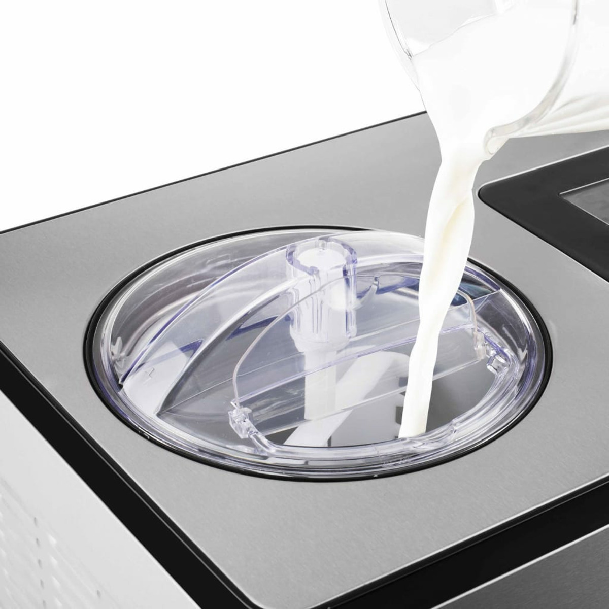 Une machine à crème glacée. Du lait est versé dans le couvercle transparent. Base en acier inoxydable.