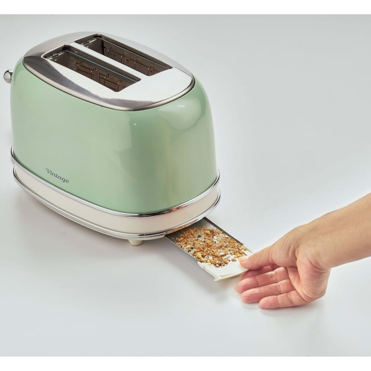 Green vintage toaster with a tray being pulled out by a hand.