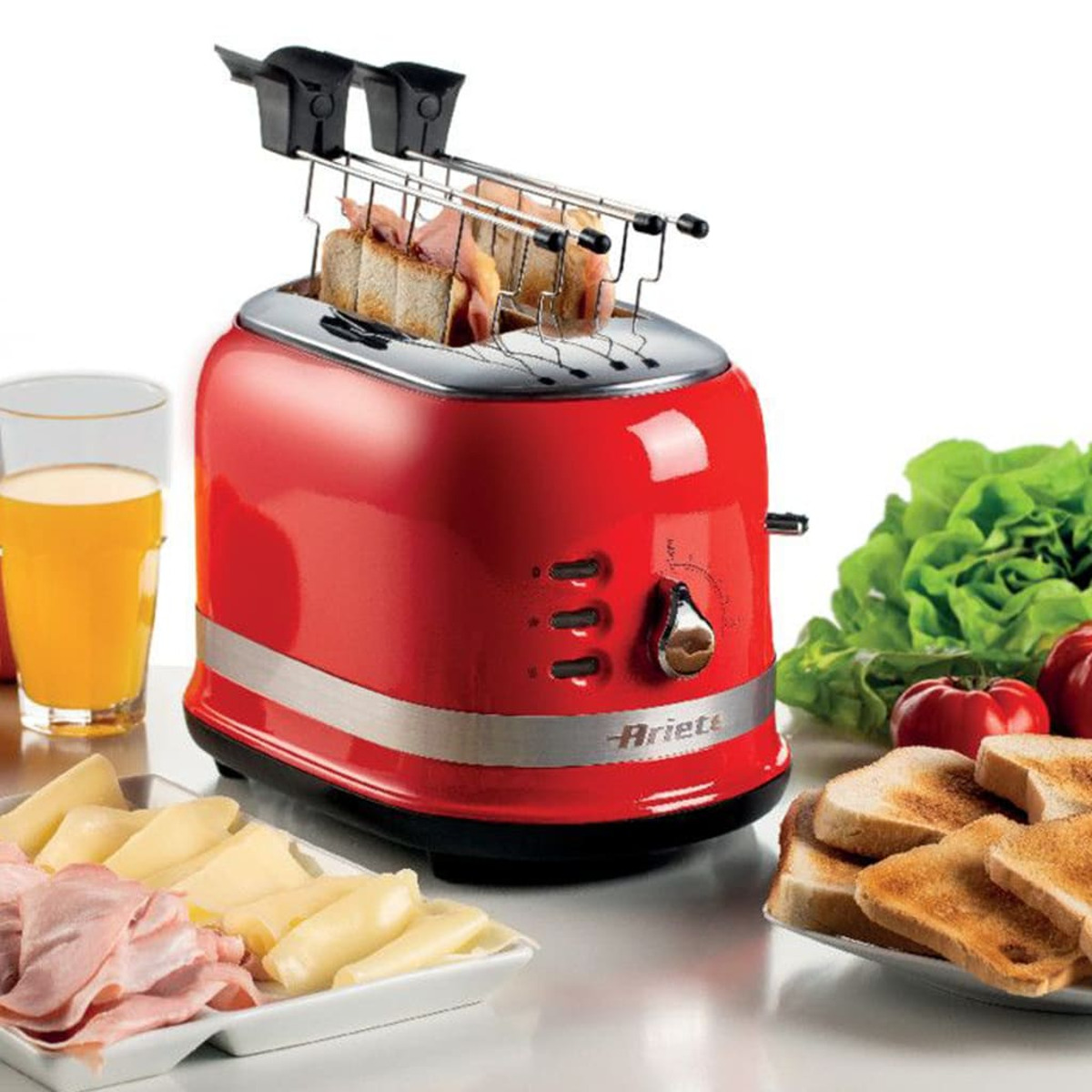 Czerwony toster z chlebem i jedzeniem. Toster na drewnianym stole.