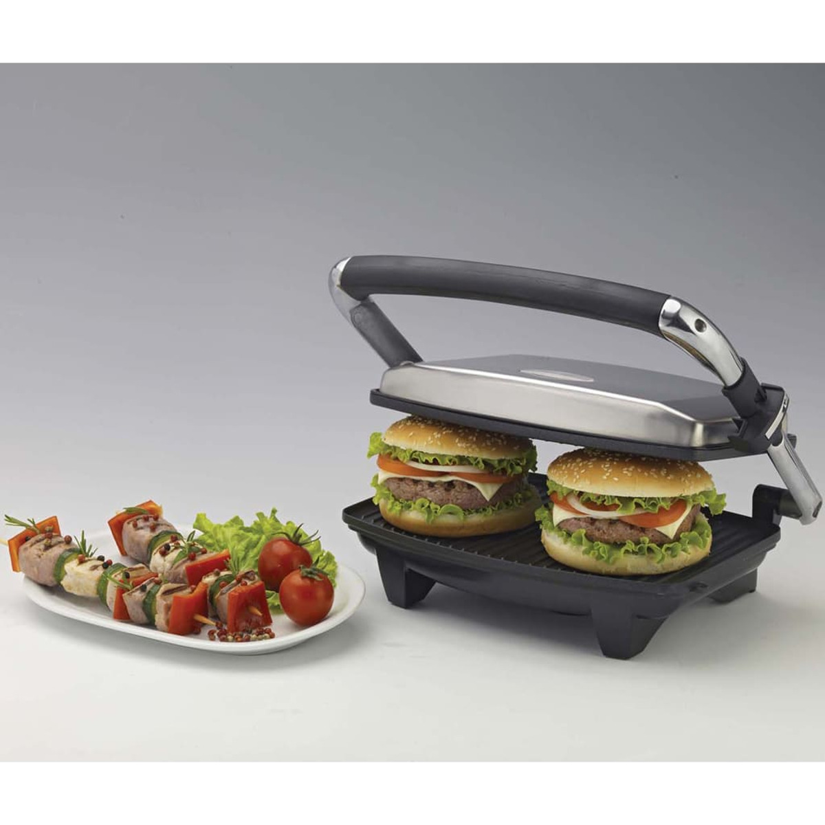 Essensgrill mit Hamburgern und Spießen mit Tomaten und Salat.