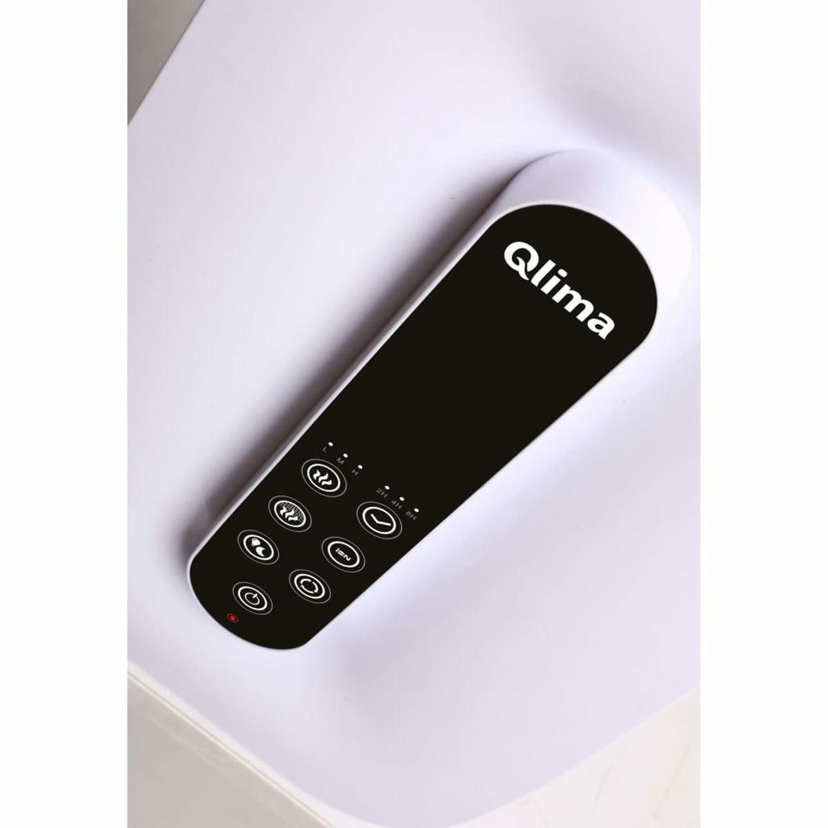 Czarny pilot na białej powierzchni. Ma kilka przycisków i nazwę 'Qlima'.