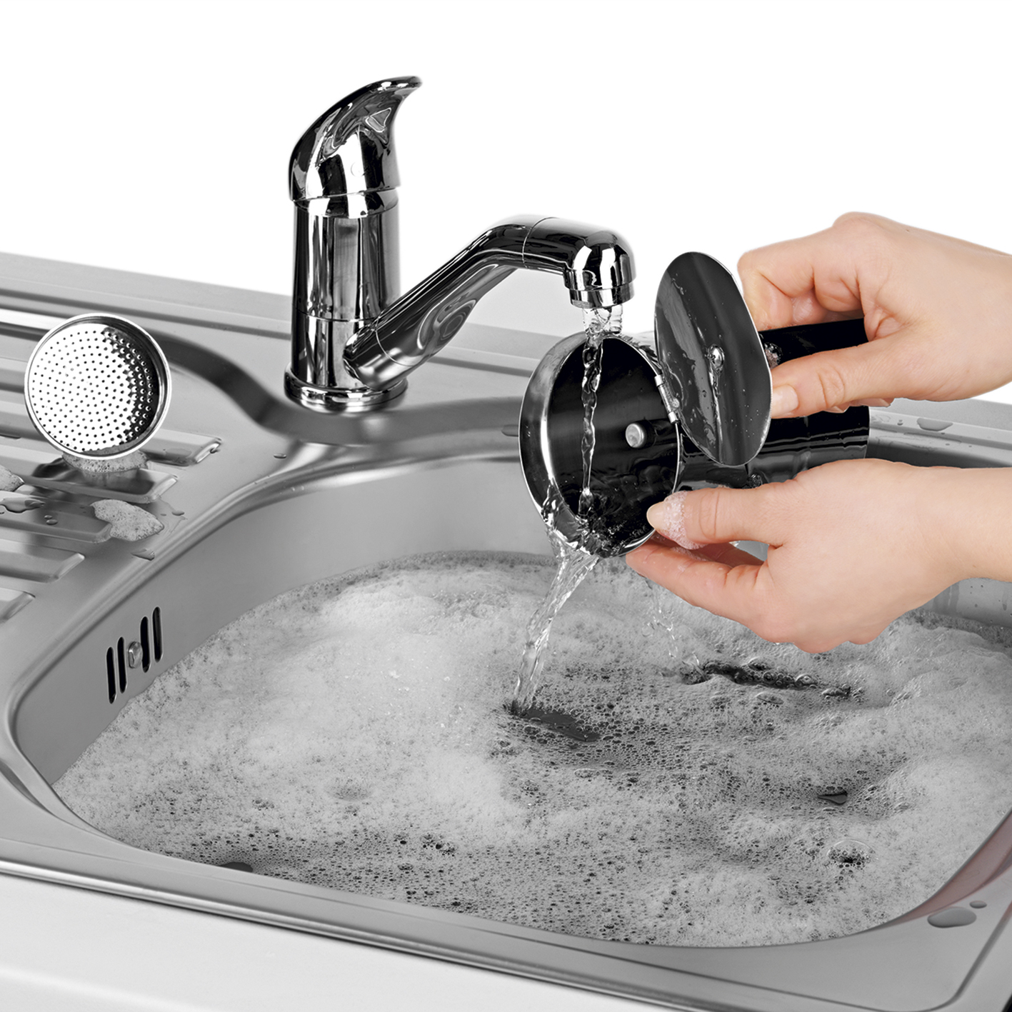 Hände waschen einen schwarzen Kaffeefilter in einem Edelstahlbecken mit Wasserhahn.