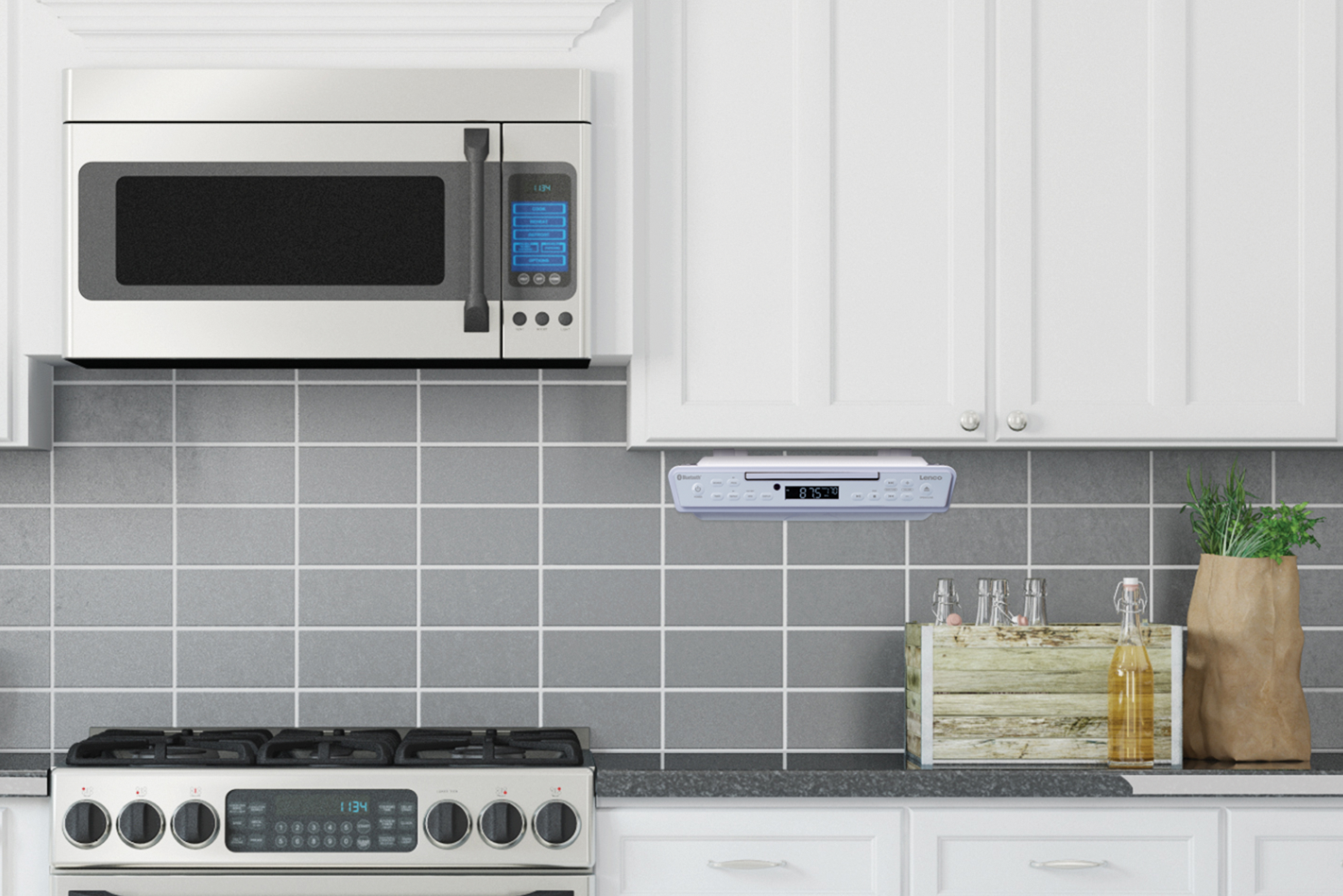 Scena kuchenna z kuchenką mikrofalową, stereo i kuchenką gazową, wszystko na szarych kafelkach.