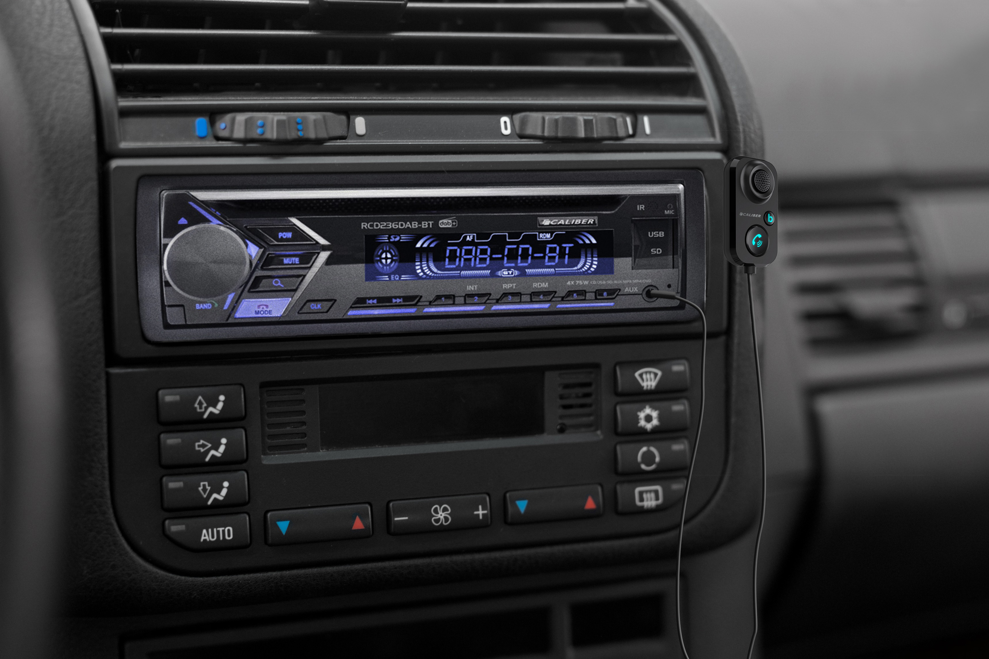 Armaturenbrett mit Radio, das eine digitale Anzeige zeigt. Ein schwarzes kabelloses Gerät ist eingesteckt.