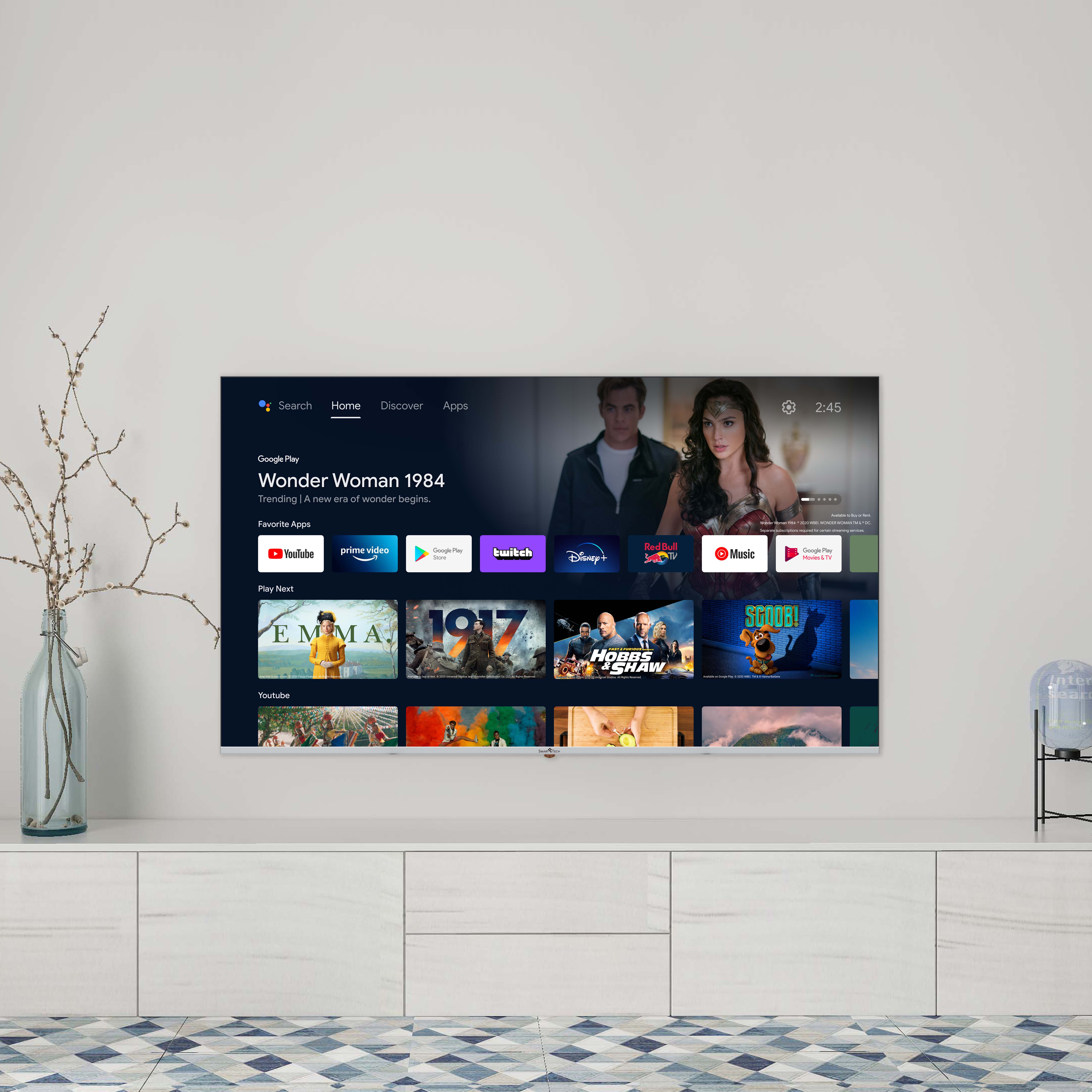Televisor mostrando Wonder Woman 1984, con aplicaciones y un mueble blanco.