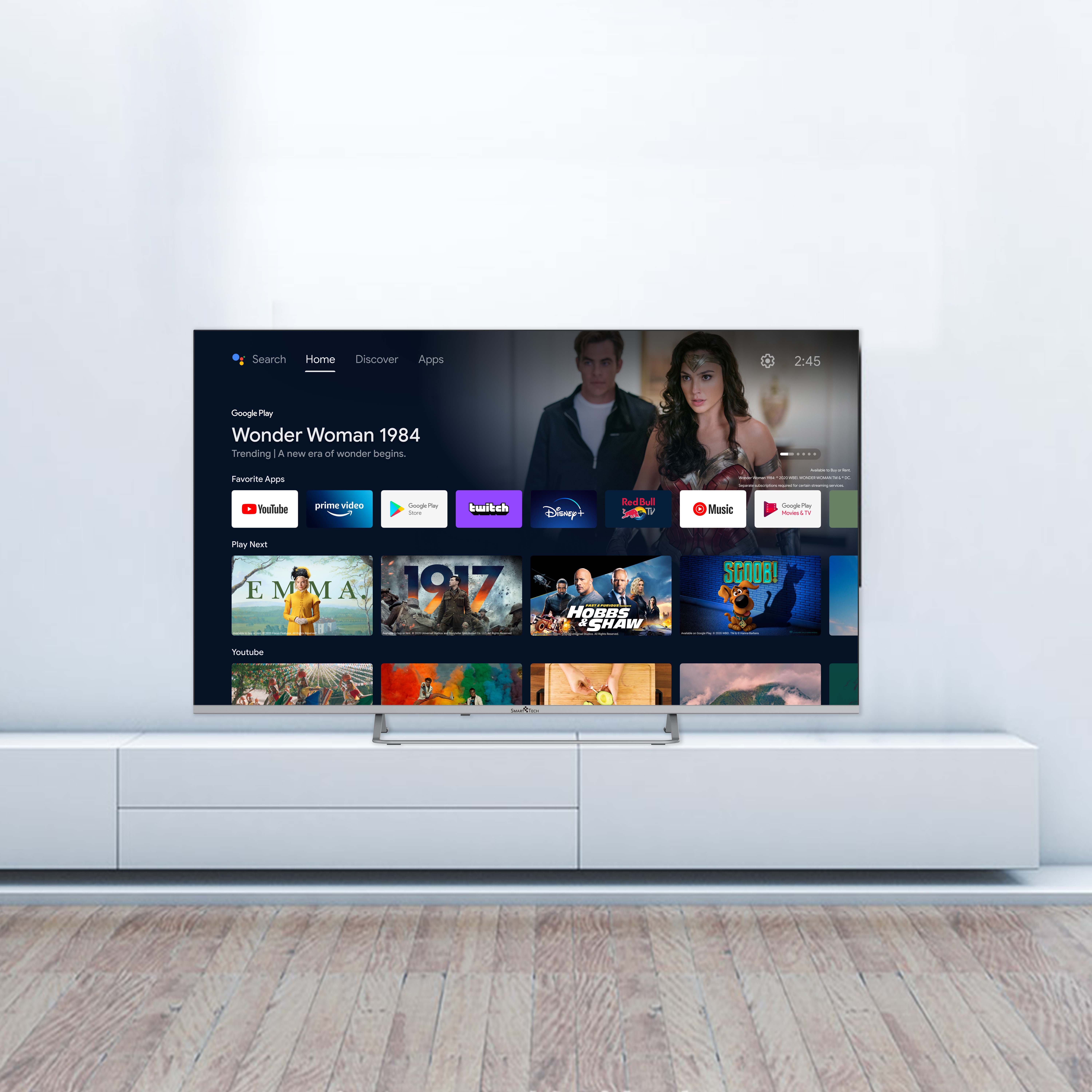 Ekran telewizora wyświetlający menu filmów. Biała szafka i drewniana podłoga w tle.