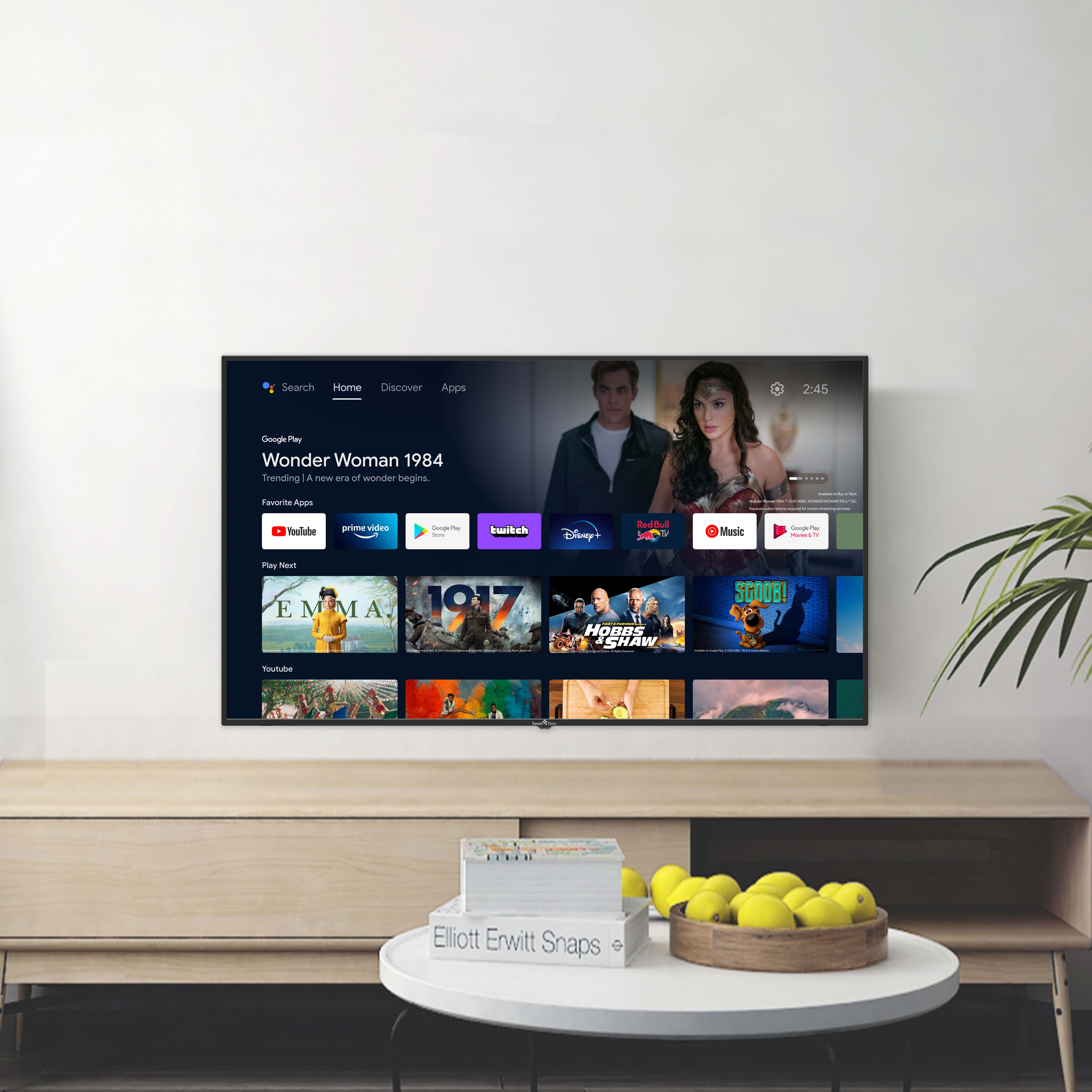Un Smart TV muestra la pantalla de inicio de un servicio de transmisión. Hay una mesa con fruta.