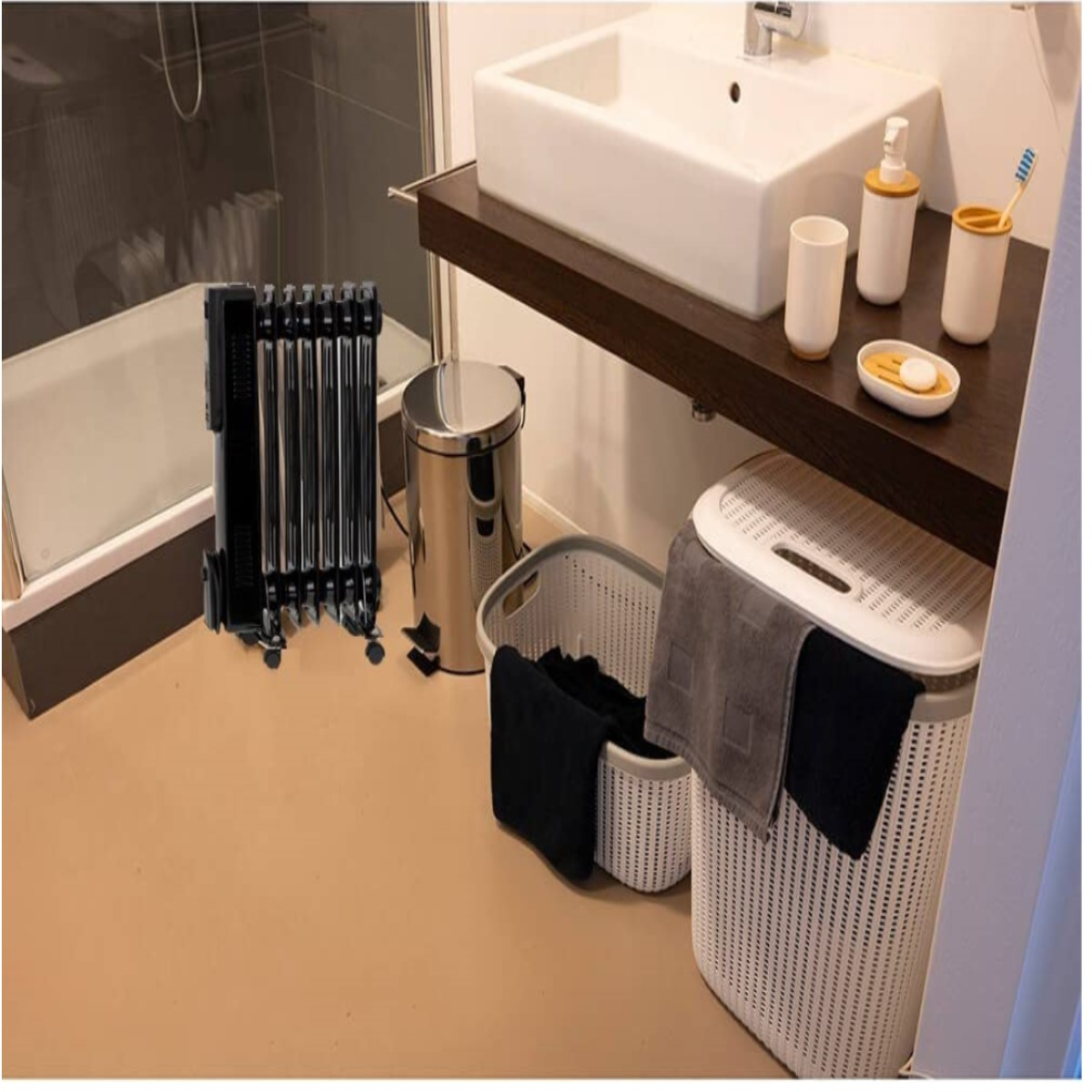 Badezimmer mit Heizkörper, Waschbecken, Mülleimer, Wäschekörben und Toilettenartikeln.