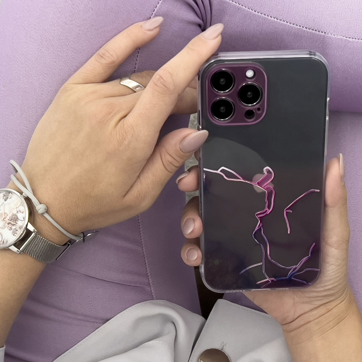 Eine Hand, die ein Telefon in einer Hülle mit abstraktem rosa Design hält.