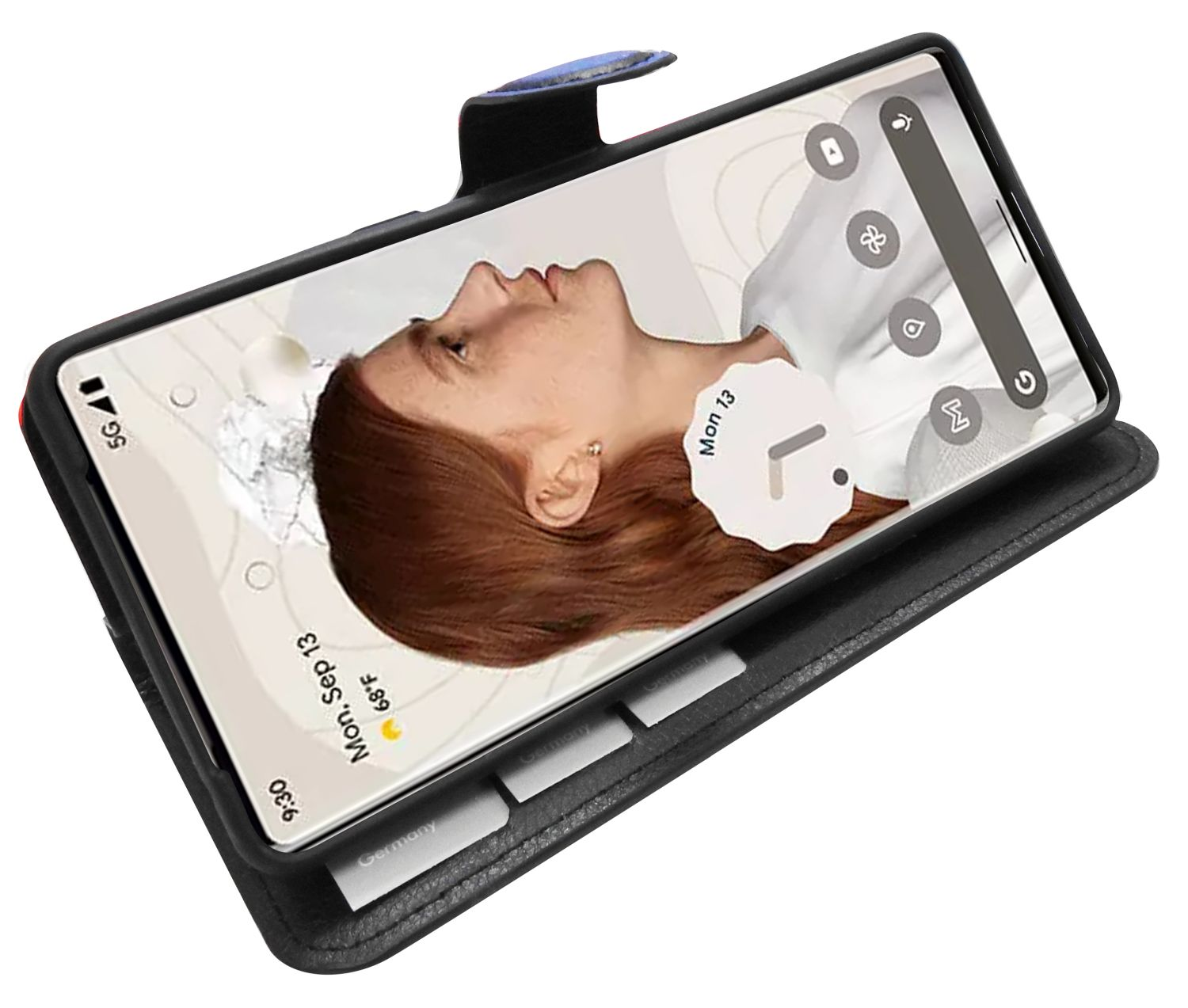 Ein Telefon in einer schwarzen Brieftaschenhülle. Der Bildschirm zeigt das Gesicht einer Frau und ein Zeit-/Datum-Widget.