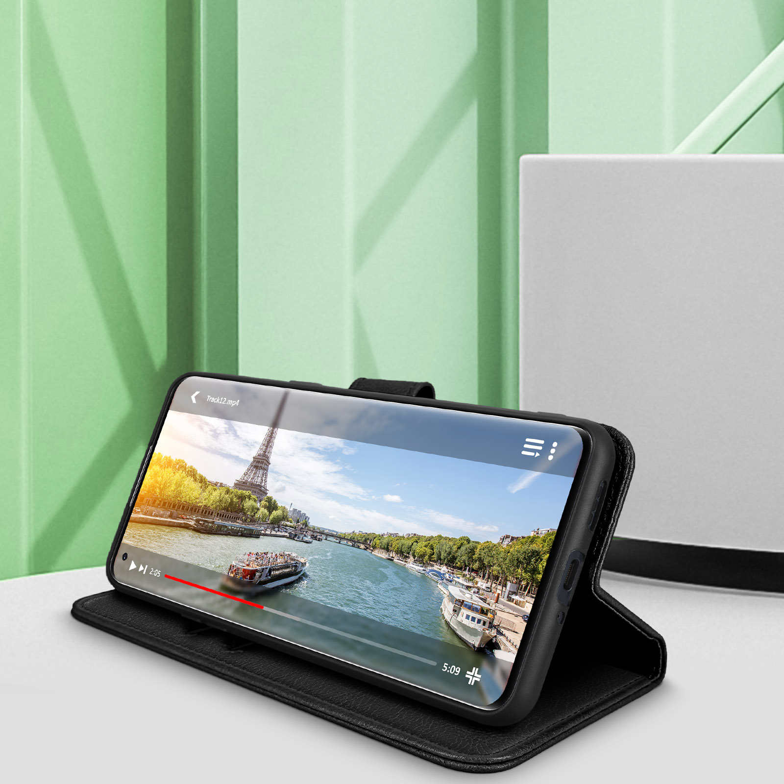 Smartphone in custodia nera, mostra un video con un fiume e una barca. Sfondo bianco.
