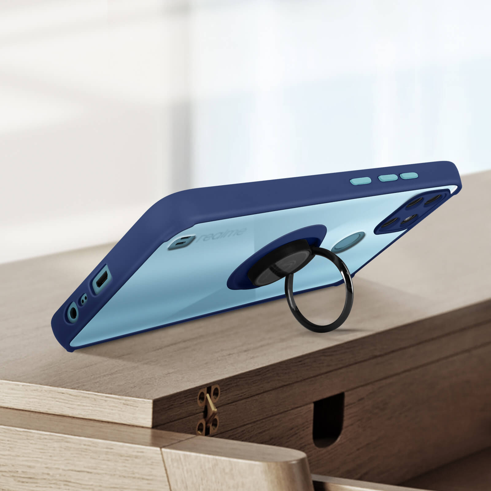 Custodia blu per telefono con un supporto ad anello nero. Lo sfondo è un tavolo di legno.