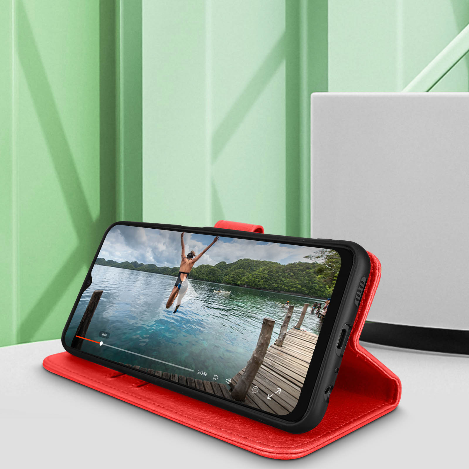 Téléphone dans un étui rouge affichant une vidéo d'une personne sautant dans l'eau.