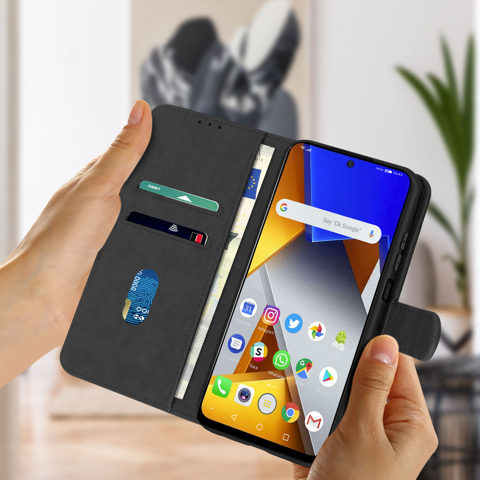 Mani che tengono un telefono nero in una custodia a portafoglio. Il telefono ha uno schermo con icone.