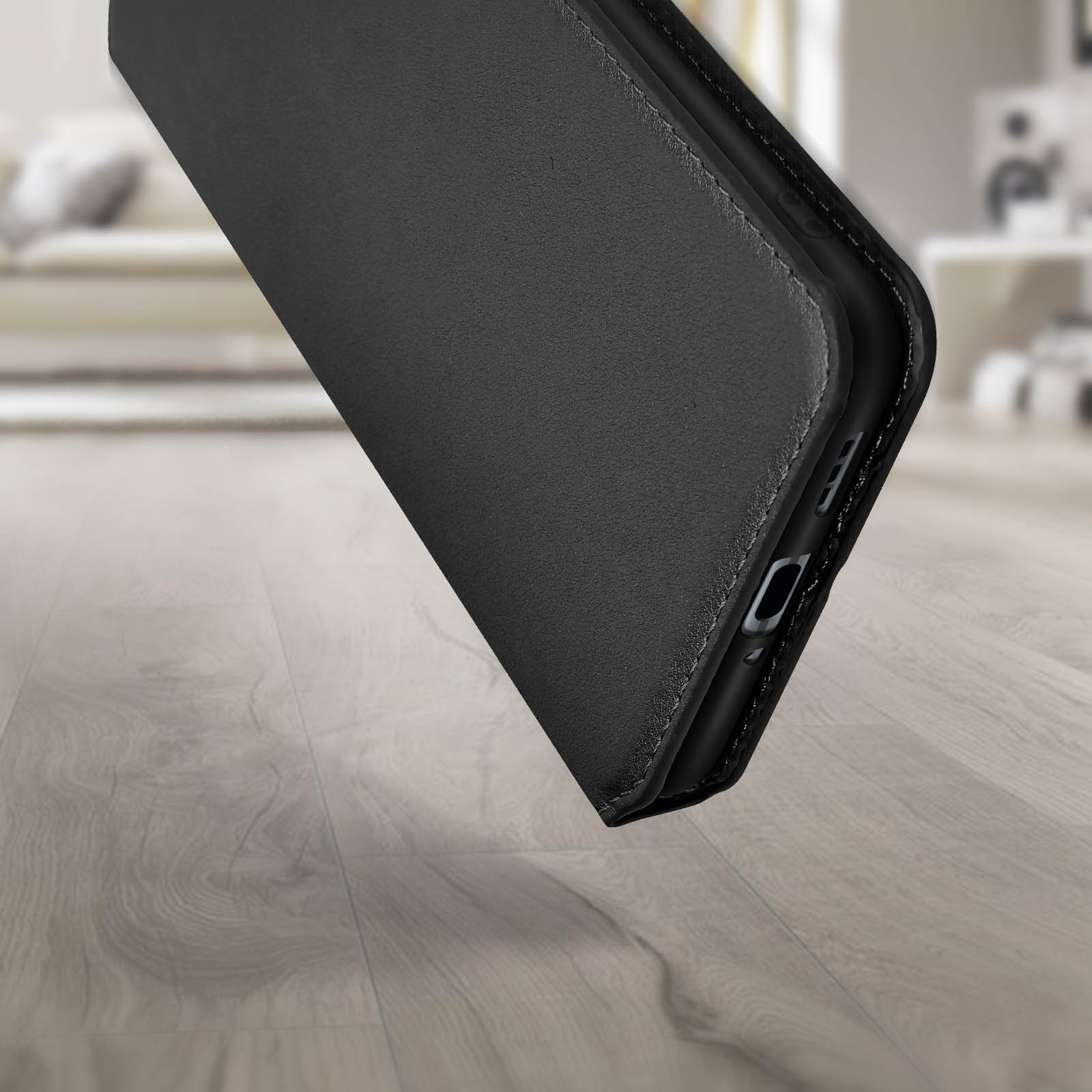 Une coque de téléphone noire est montrée en angle, affichant le bord inférieur et le côté.