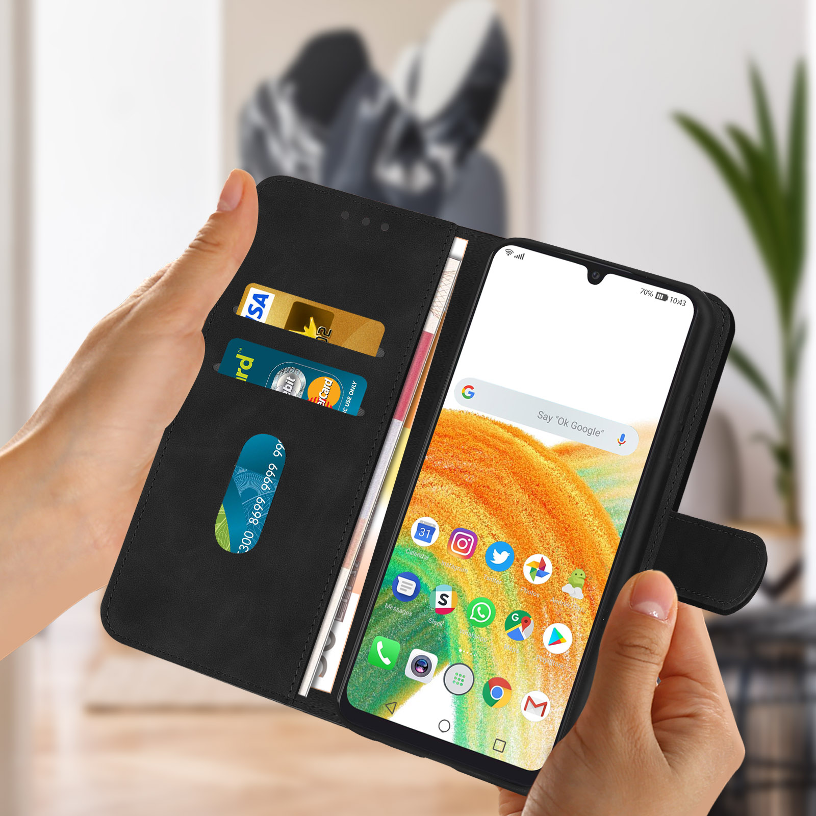 Mains tenant un étui de téléphone avec un téléphone à l'intérieur. Le téléphone affiche des applications et de l'argent.