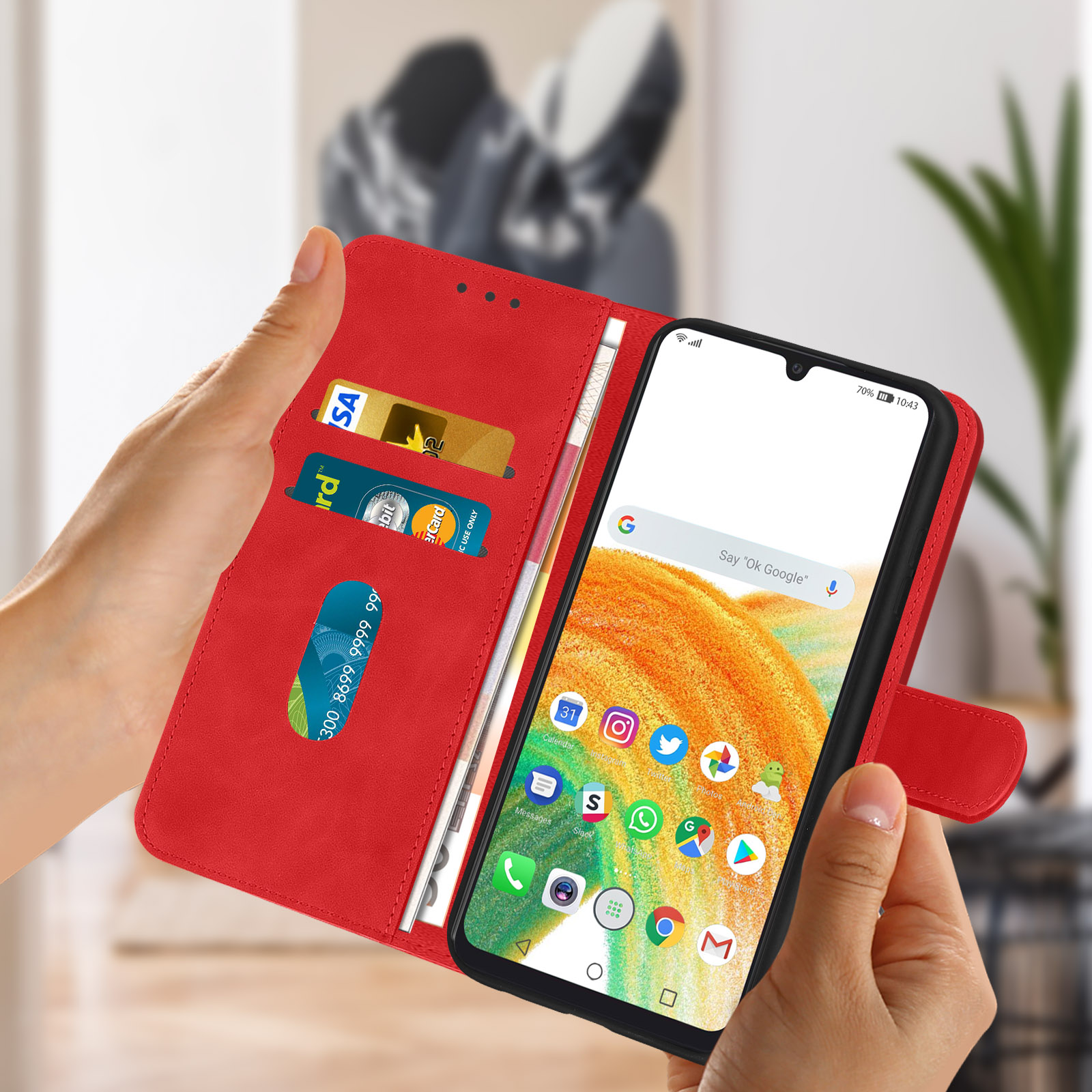Mains tenant un étui de téléphone rouge. Le téléphone affiche un écran d'application. Le fond est un mur.