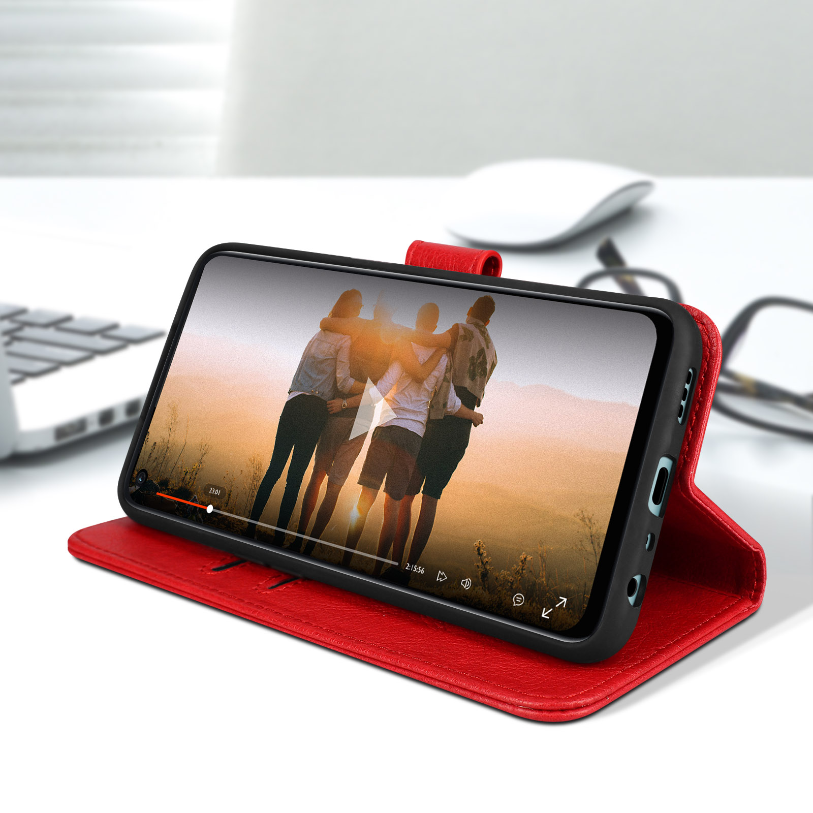Telefoon in een rode hoes die een video weergeeft, op een witte tafel, met een laptop en muis.