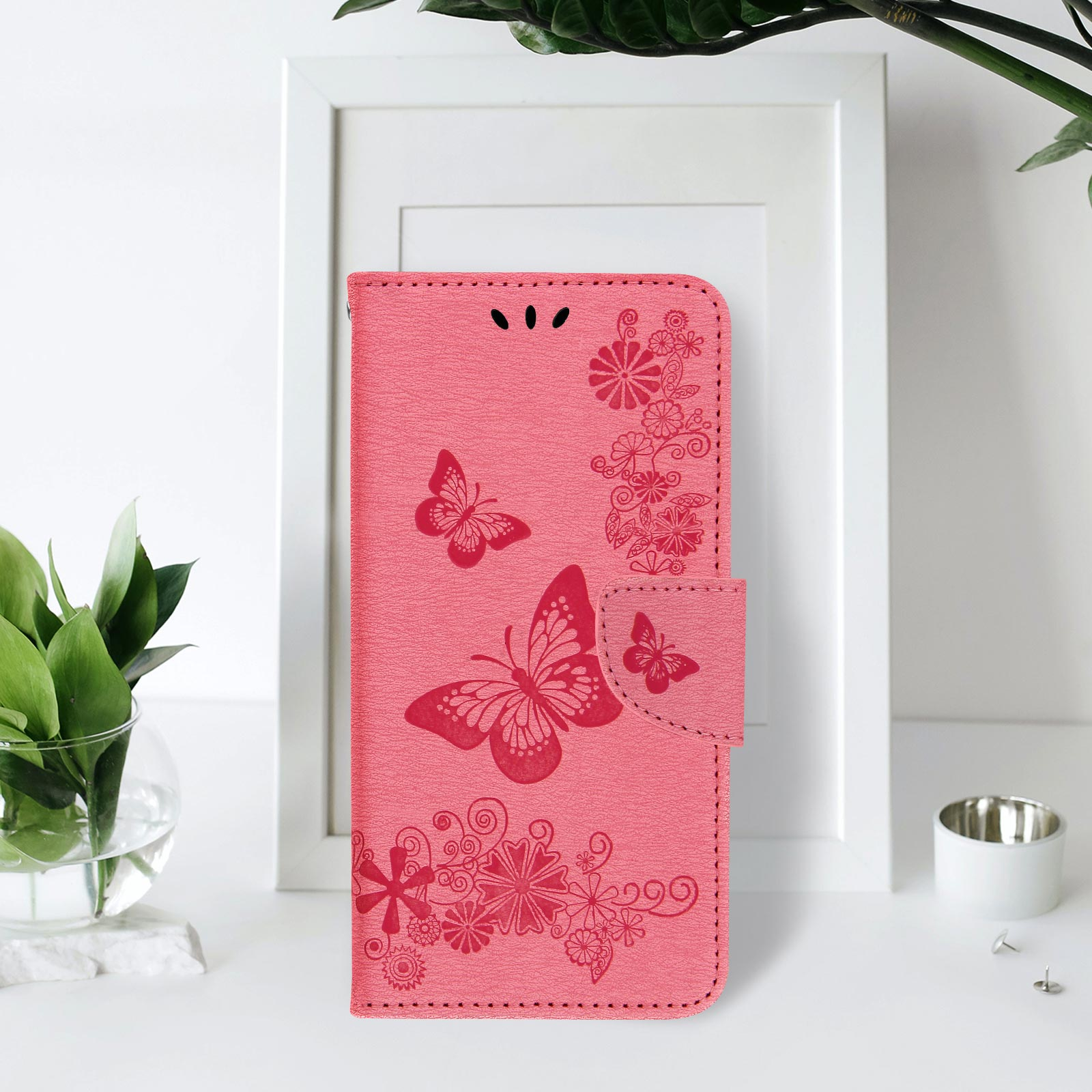 Custodia rosa con farfalle e fiori. La custodia è aperta.