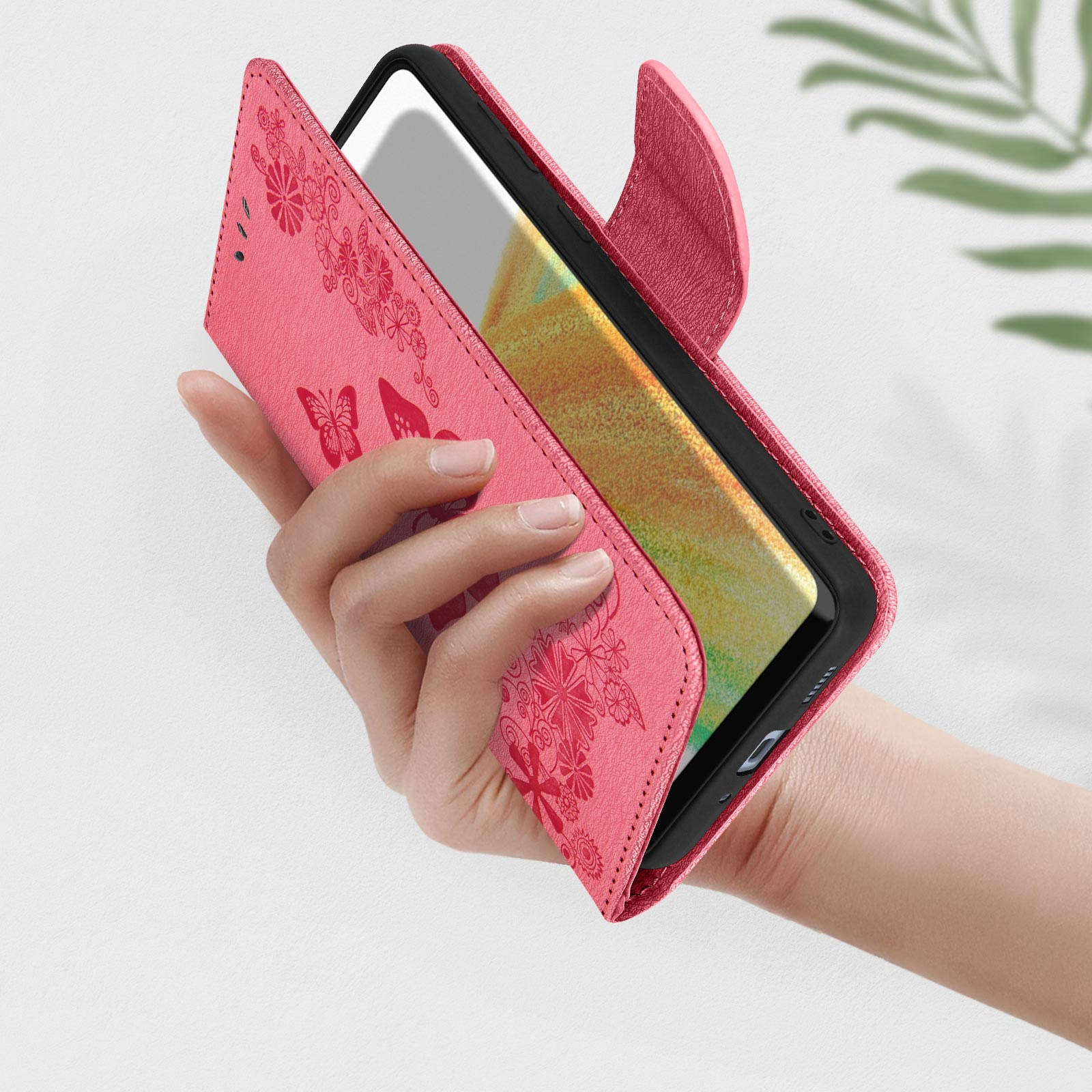 Custodia rosa aperta, che rivela il telefono. Dettagli floreali e farfalle.
