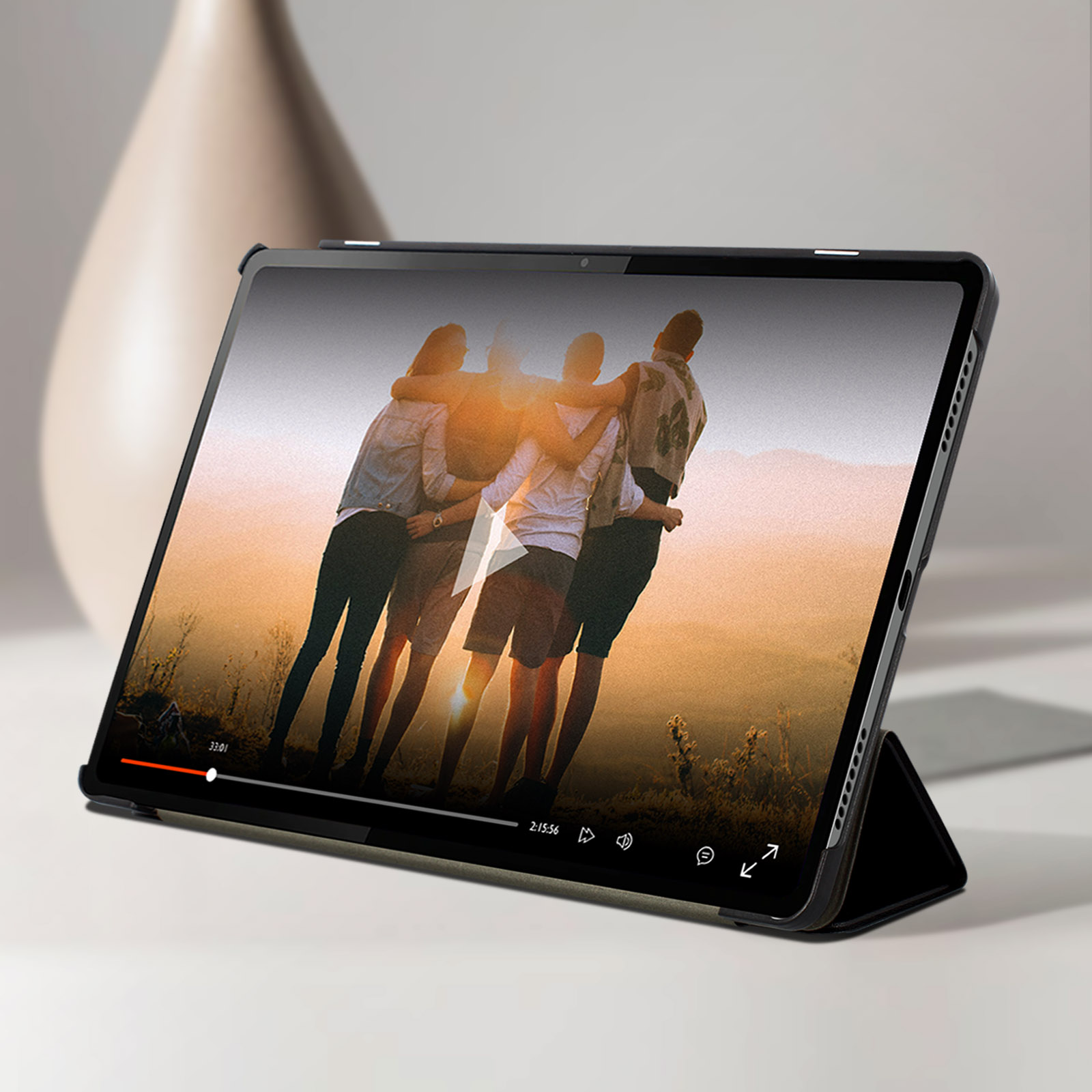 Tablet che riproduce un video di persone che si abbracciano. Lo sfondo è un tramonto su un campo.