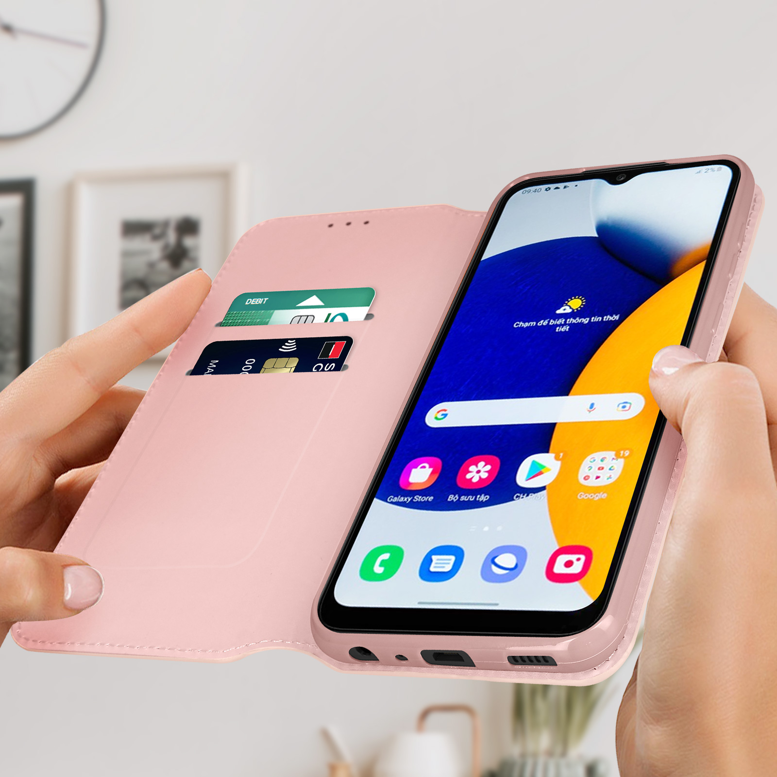 Custodia rosa con telefono. Carte visibili. Mani umane che tengono la custodia. Sfondo: immagini sfocate.