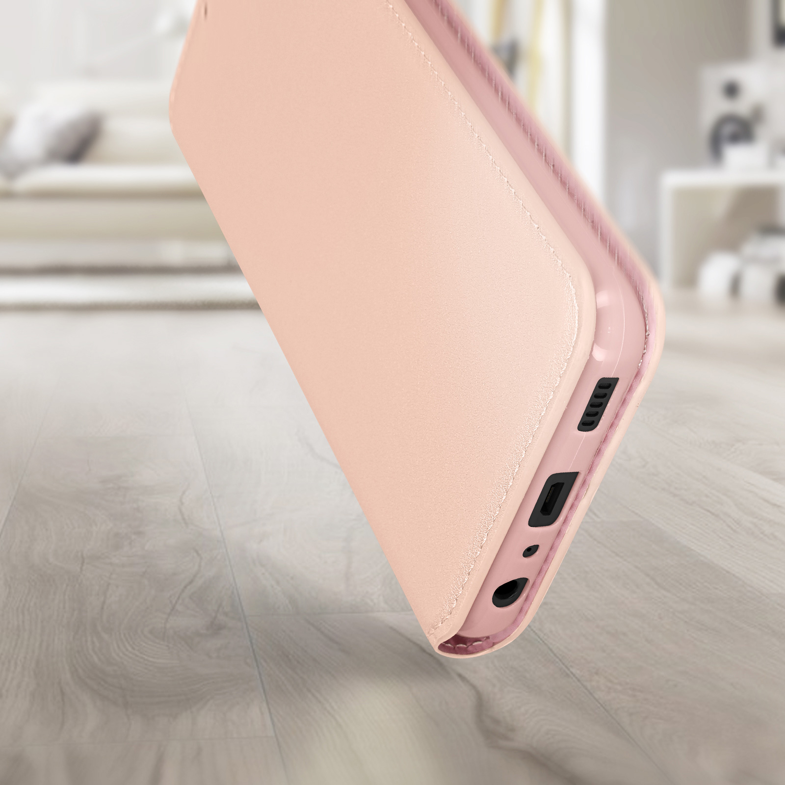 Custodia rosa per telefono aperta con un telefono all'interno su una superficie di legno, sfondo sfocato.