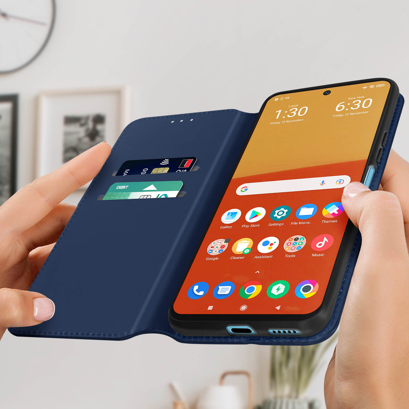 Een blauwe telefoonhoes open, met een telefoon die het scherm toont, vastgehouden door handen.