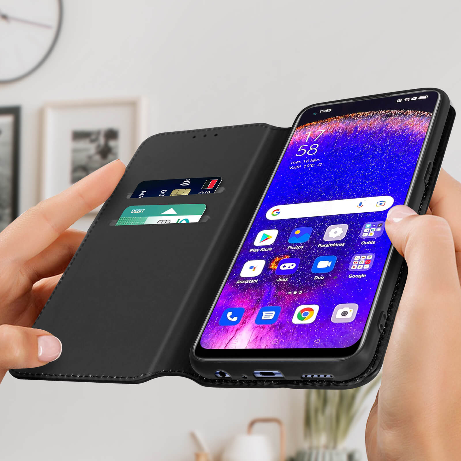 Zwarte telefoonhoes met een telefoon die een startscherm met apps toont. De telefoon wordt door handen vastgehouden.