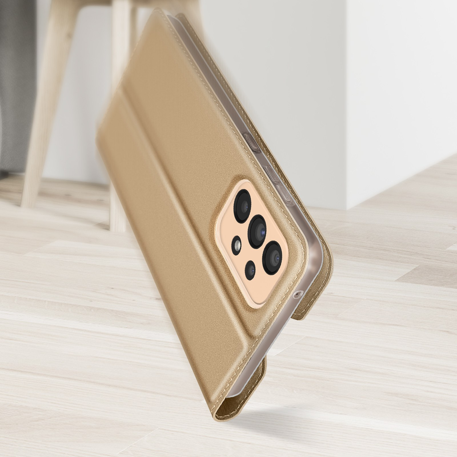 Una custodia per telefono dorata, aperta, con un telefono all'interno. È angolata su una superficie di legno, con sfondo.
