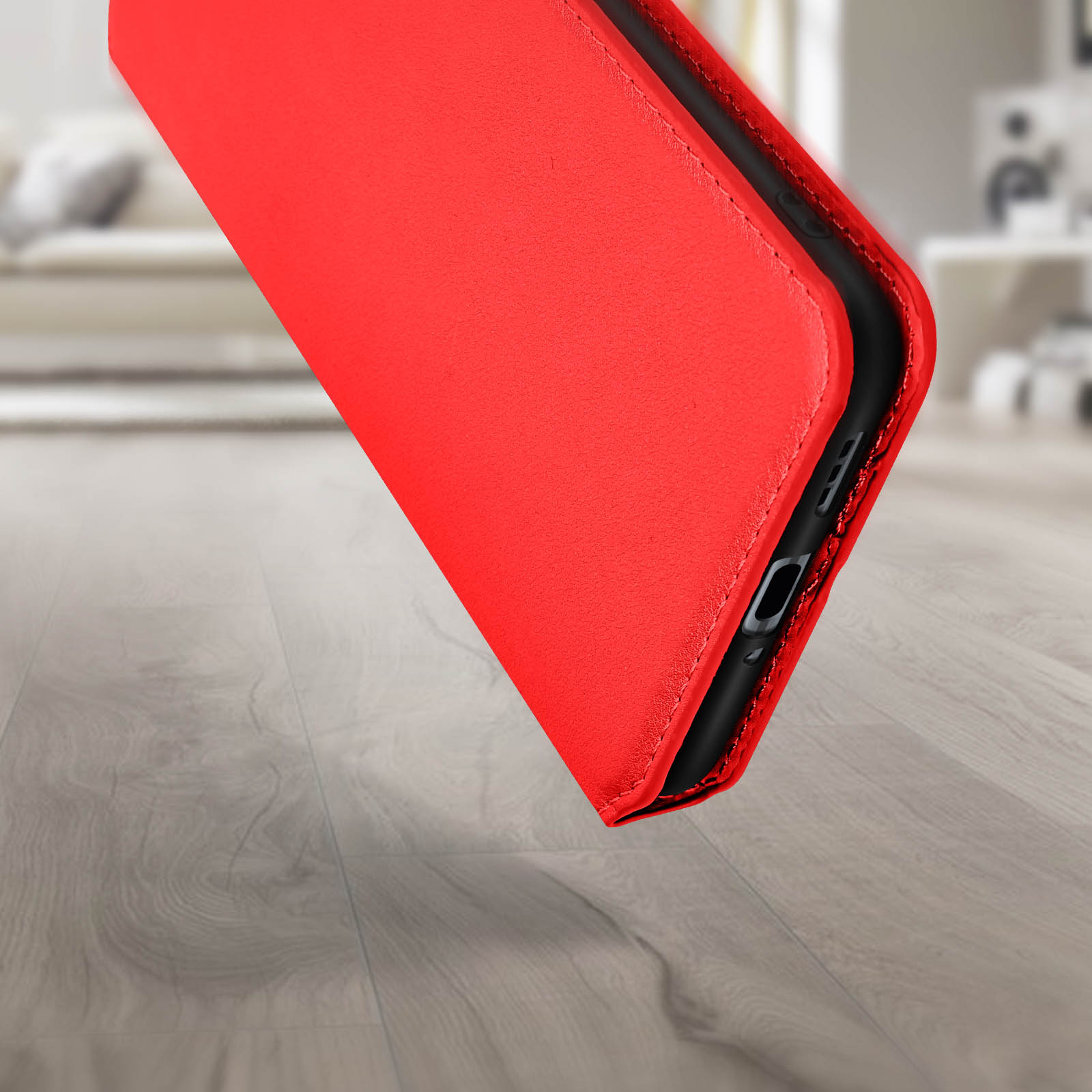 Custodia per telefono in pelle rossa, leggermente aperta, che rivela il lato del telefono con le porte.