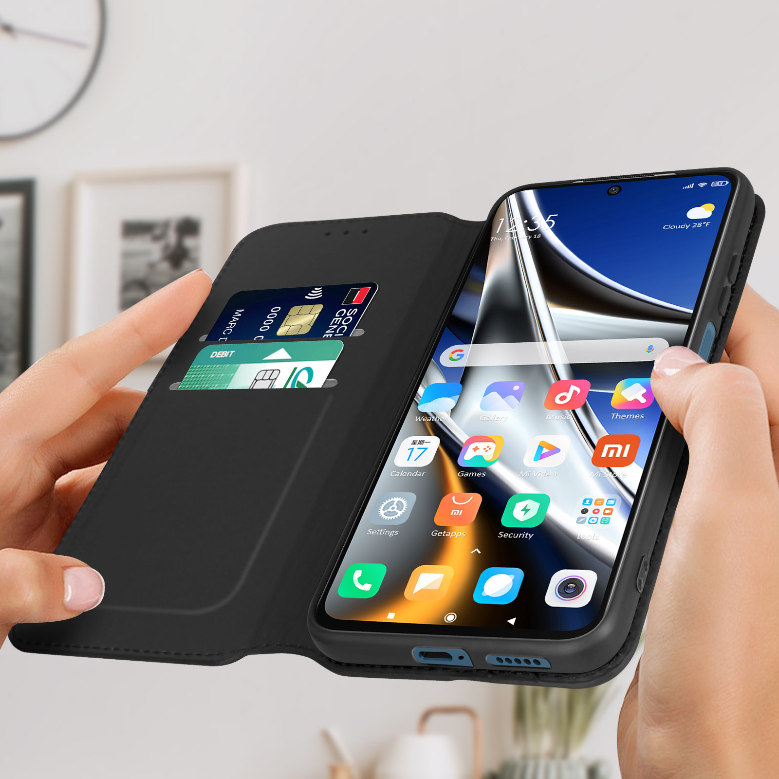 Un telefono in una custodia a portafoglio nera, con carta di credito e schermo con app.