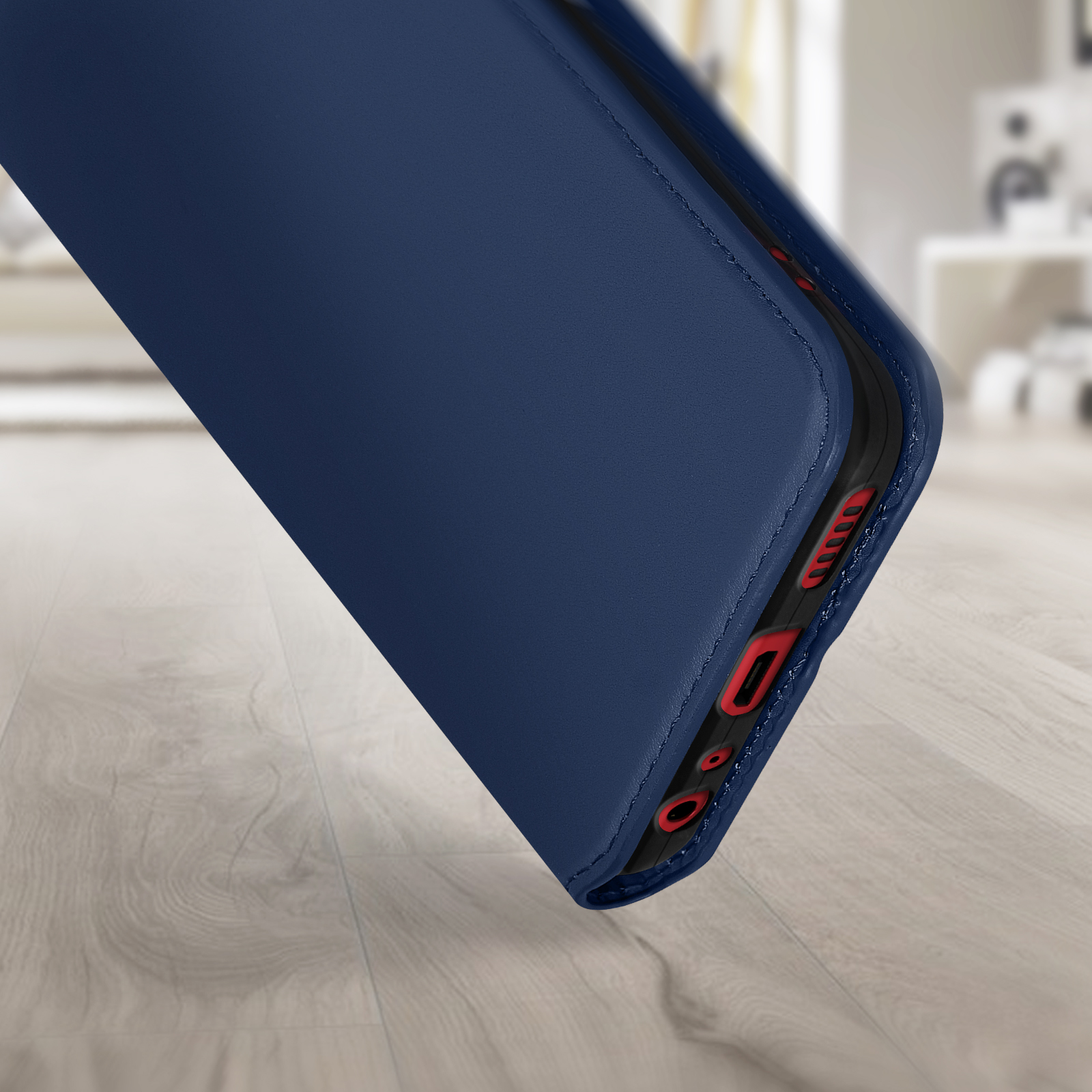 Un primo piano di una custodia blu per telefono con uno sfondo di pavimento in legno.