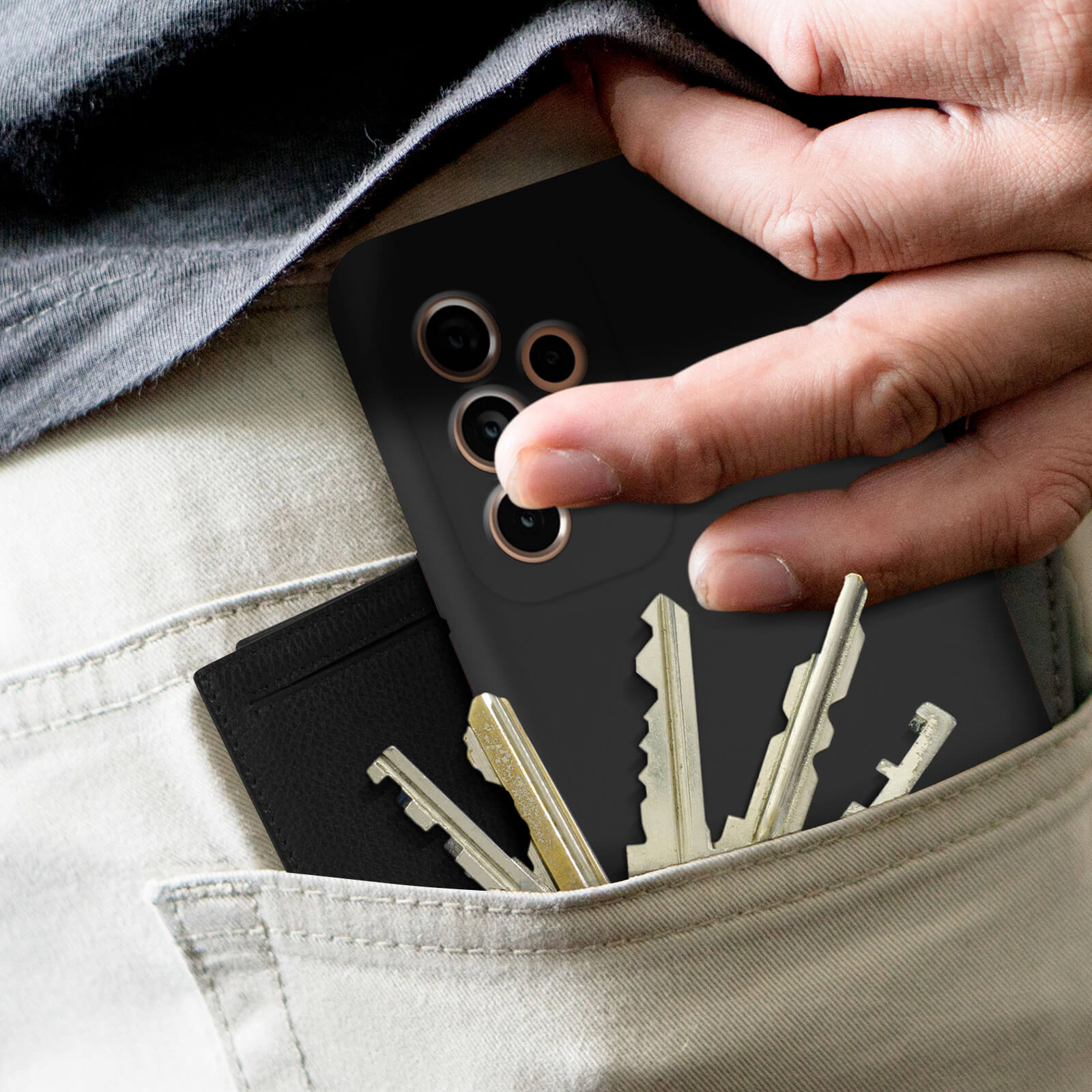 Main dans une poche avec téléphone, clés et porte-cartes. La poche est beige.