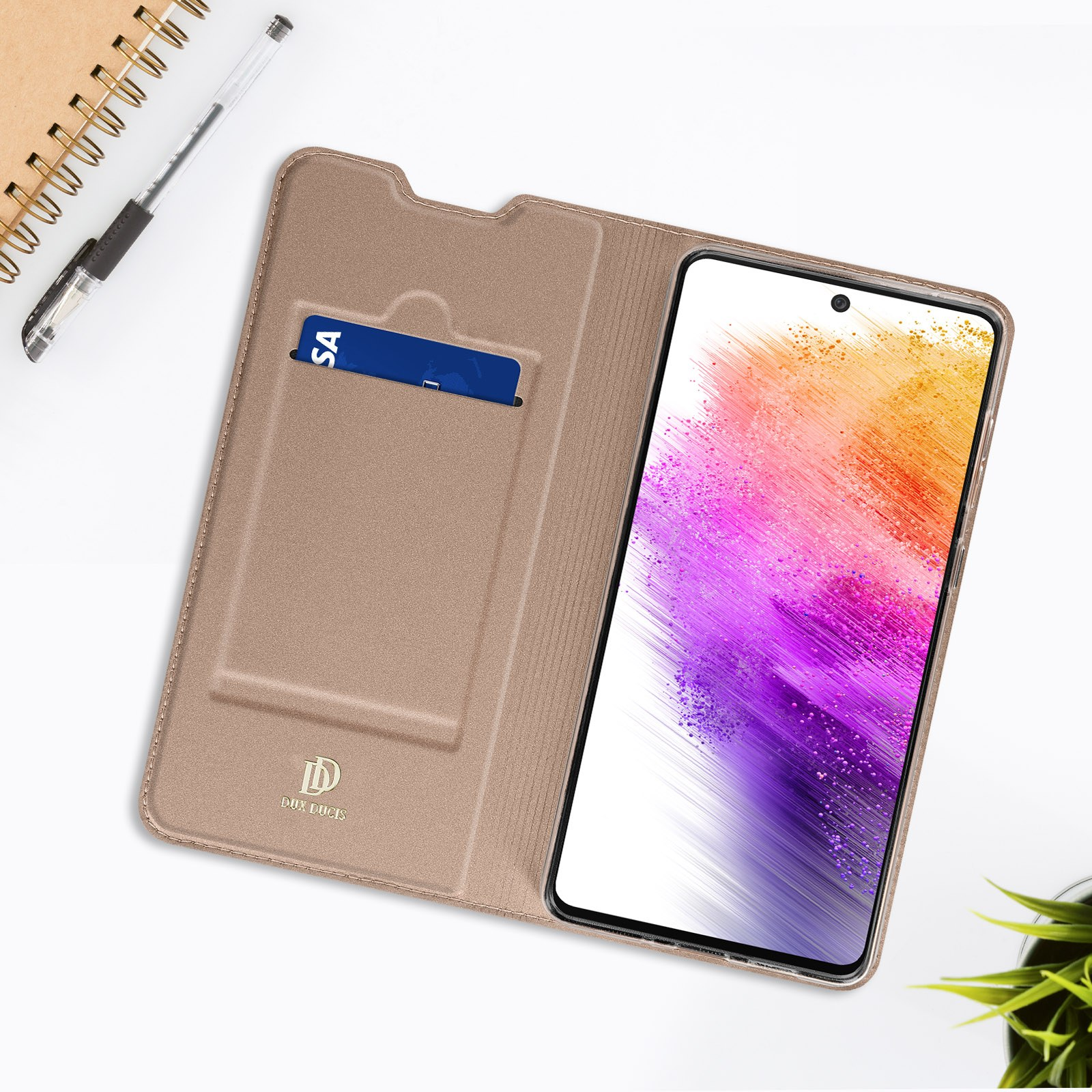 Telefono in una custodia a portafoglio beige aperta. Una carta è nello slot per carte. Penna e blocco note sullo sfondo.