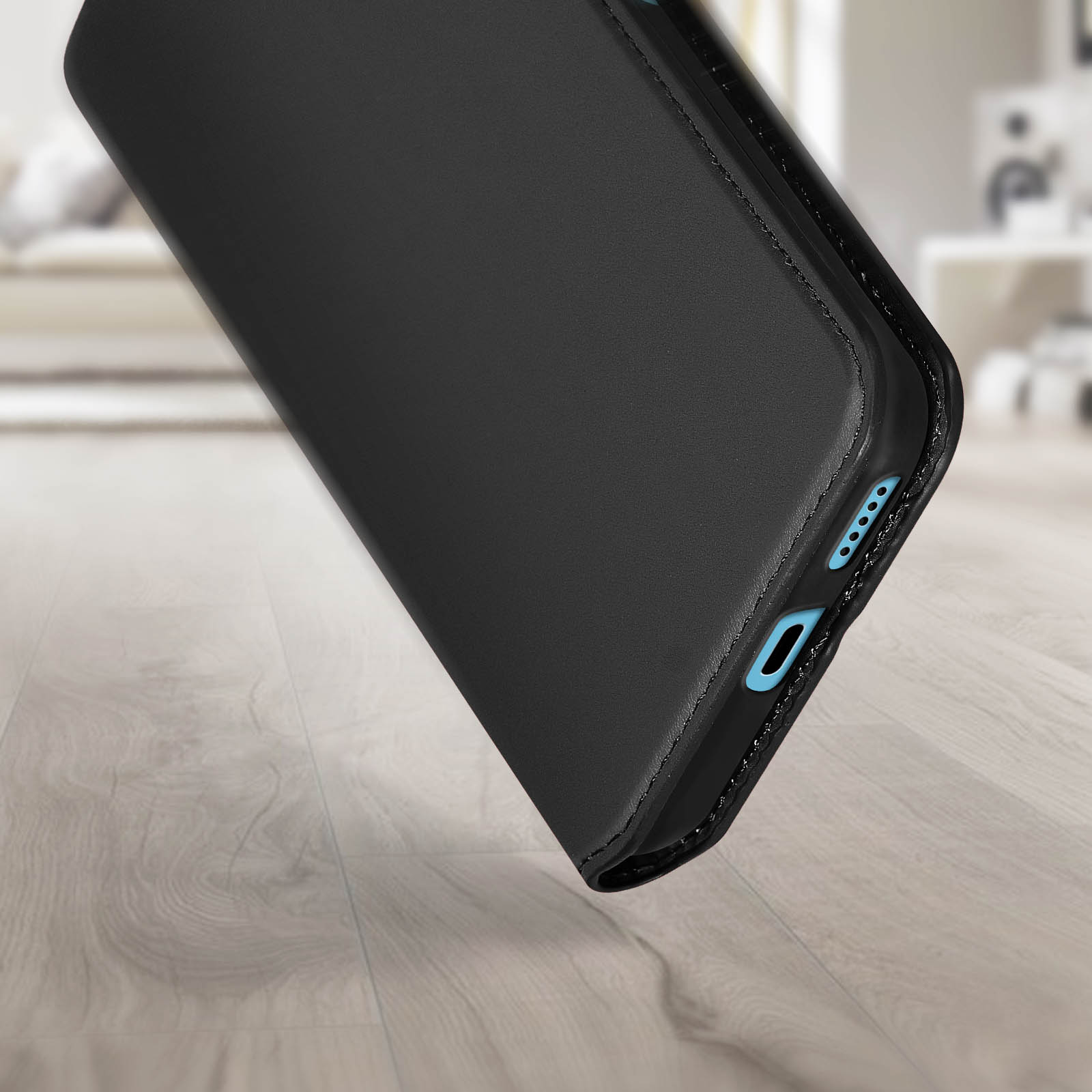 Un étui de téléphone noir sur une surface en bois. L'étui a une découpe pour le port de charge. La surface est floue.