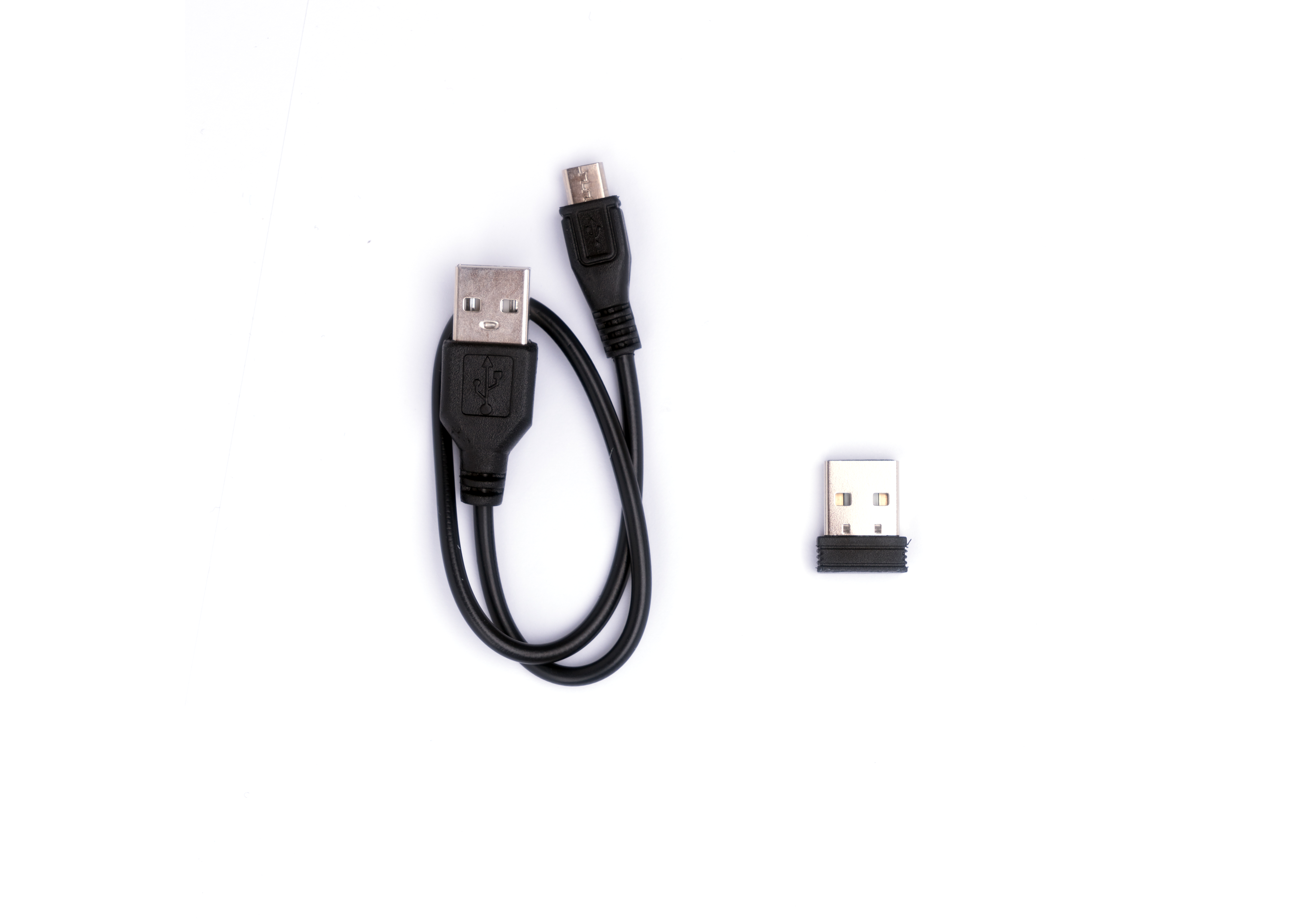 Cavo USB nero e un adattatore USB su una superficie bianca. Il cavo ha un'estremità micro USB.