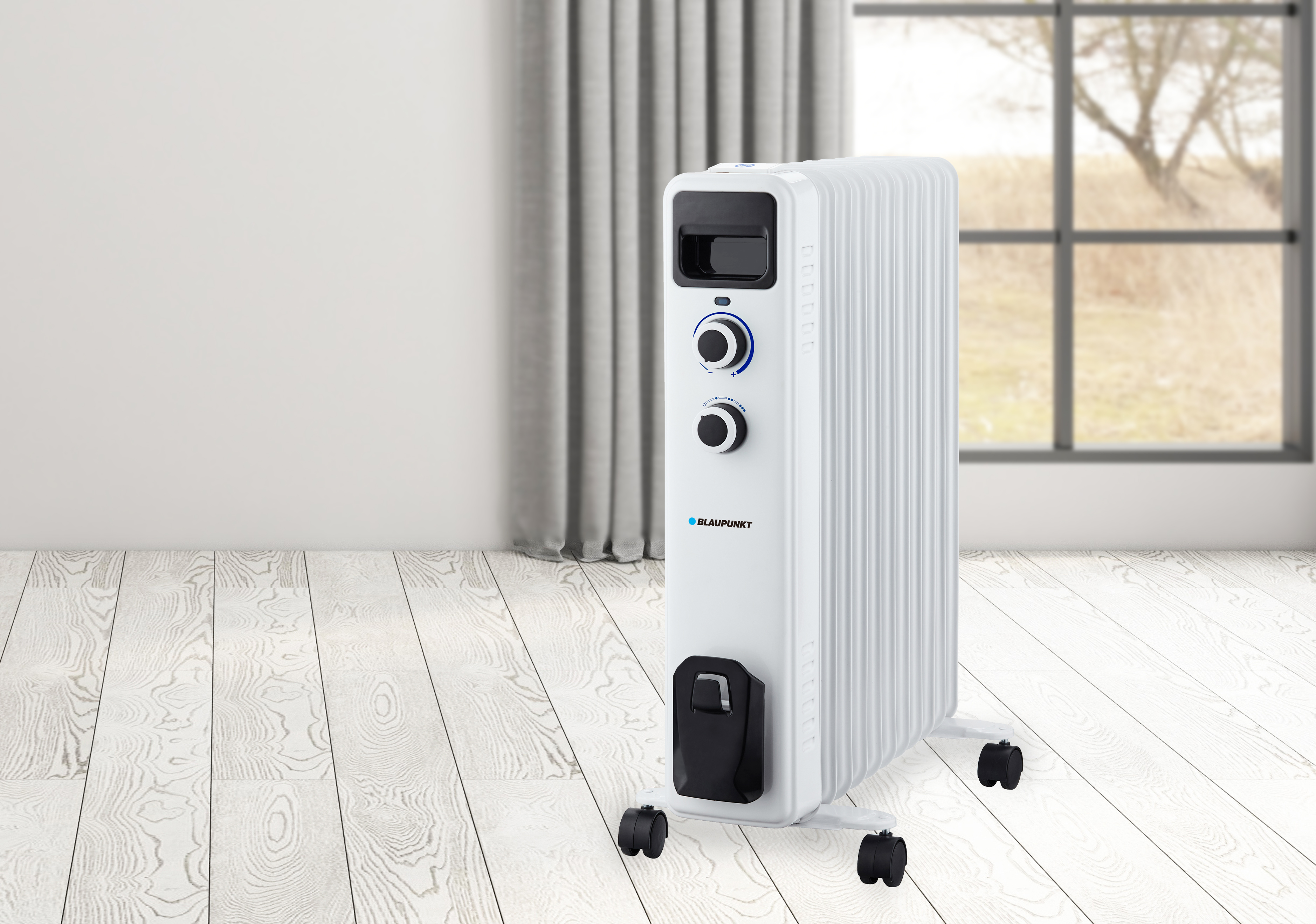 Un termoventilatore elettrico bianco con manopole di controllo, su ruote, in una stanza.