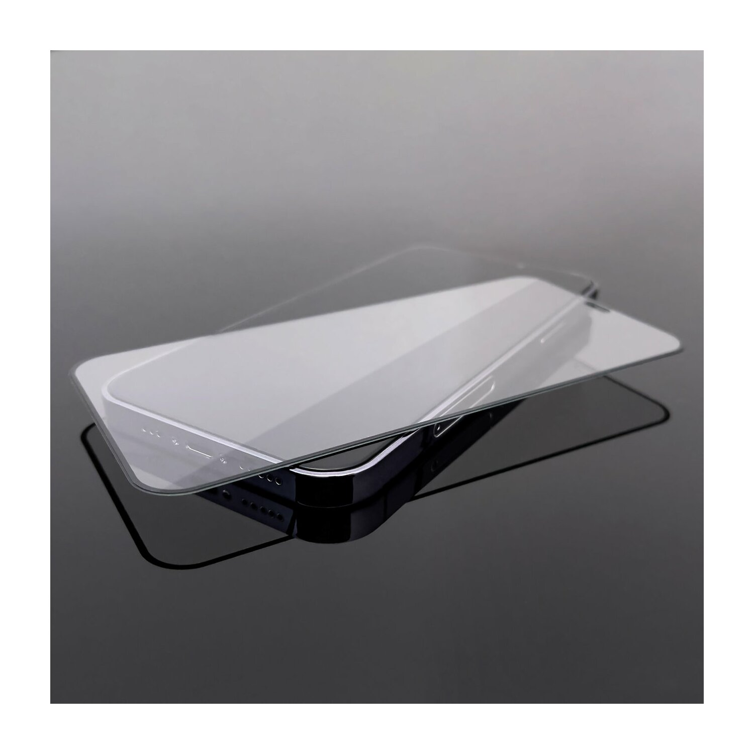 Zwei transparente Displayschutzfolien auf einem Telefon, spiegelnd auf glänzender Oberfläche.