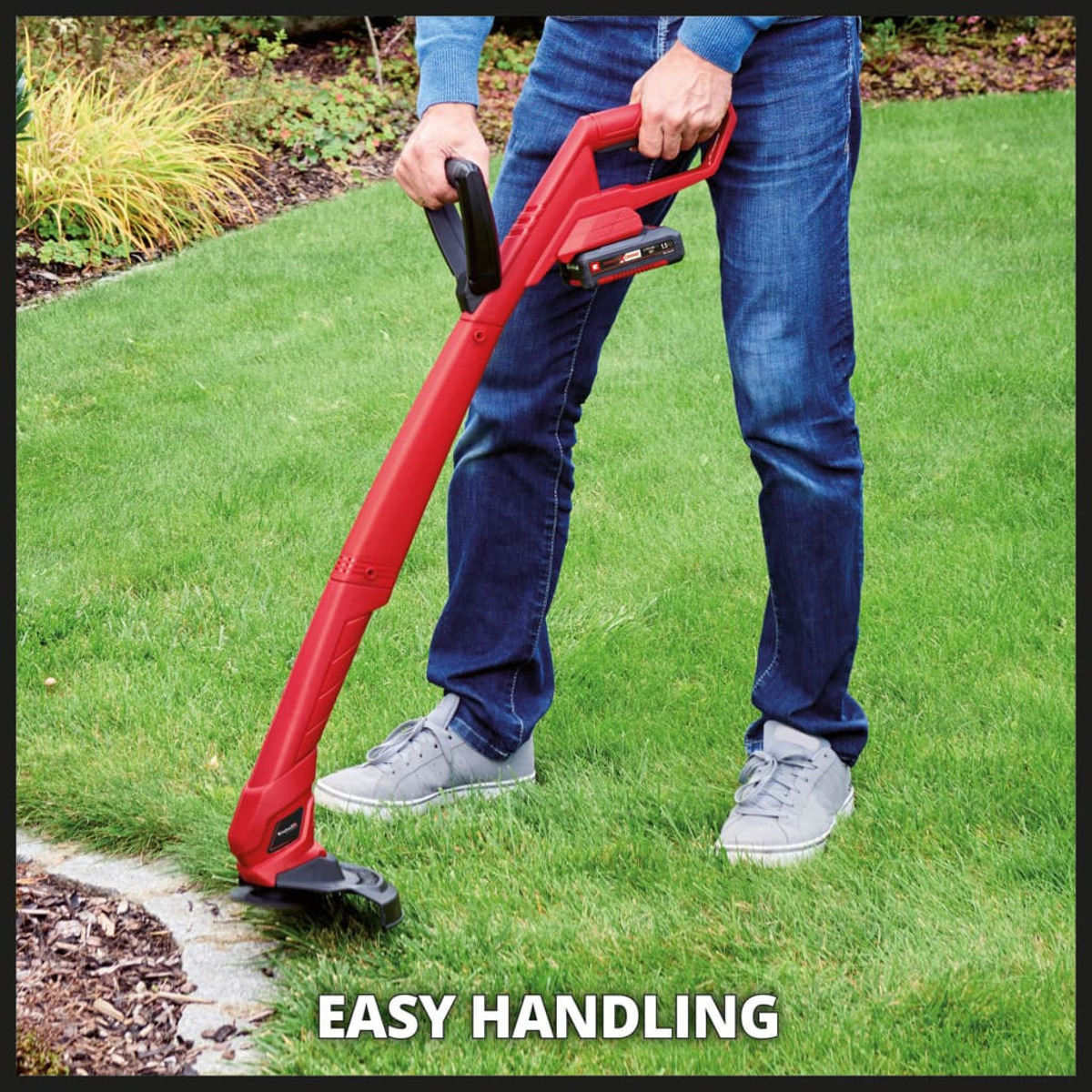 Una persona usando un cortador de maleza rojo en un césped, con la etiqueta EASY HANDLING.