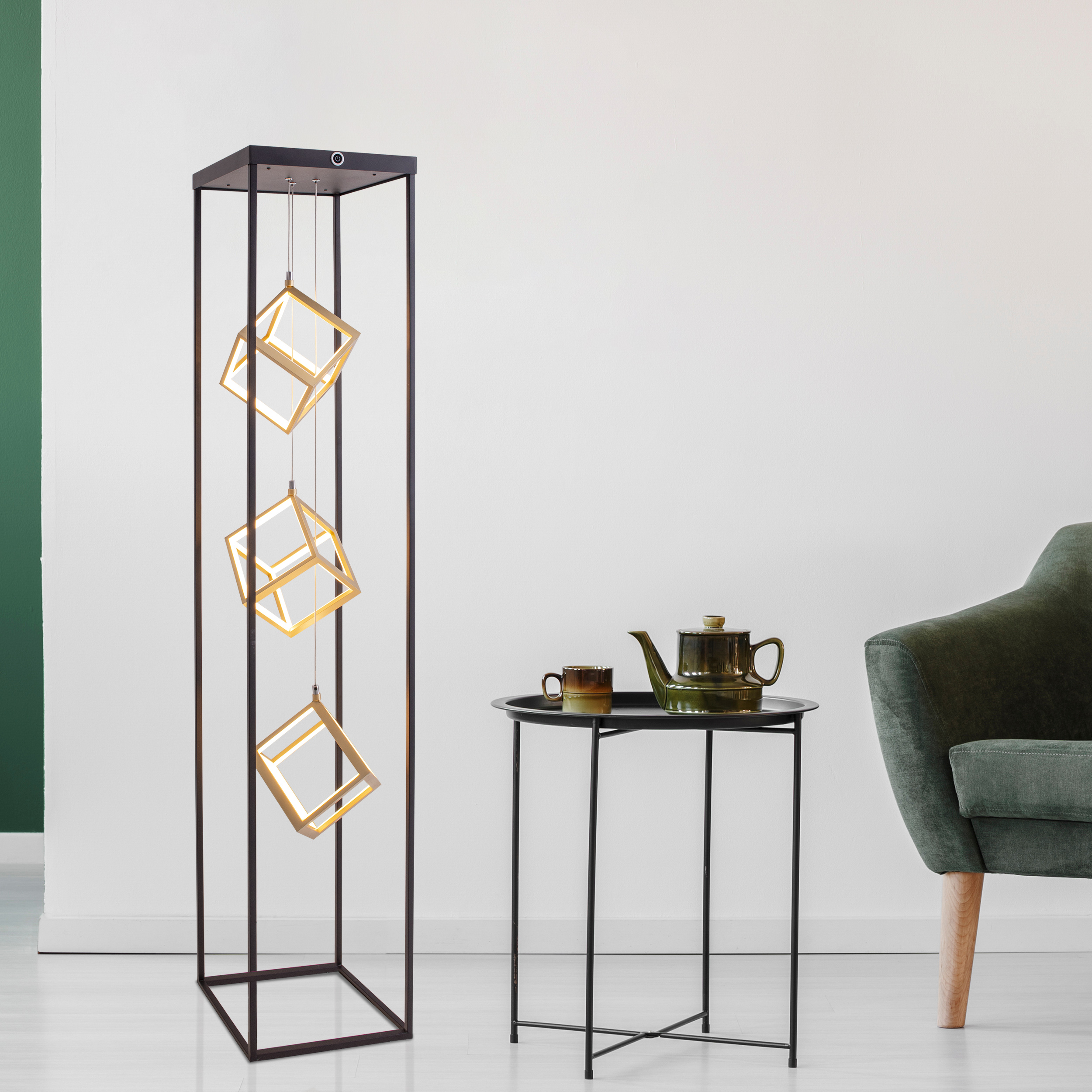 Moderne Stehlampe mit drei beleuchteten würfelförmigen Lichtern. Schwarzer Rahmen und Tisch.
