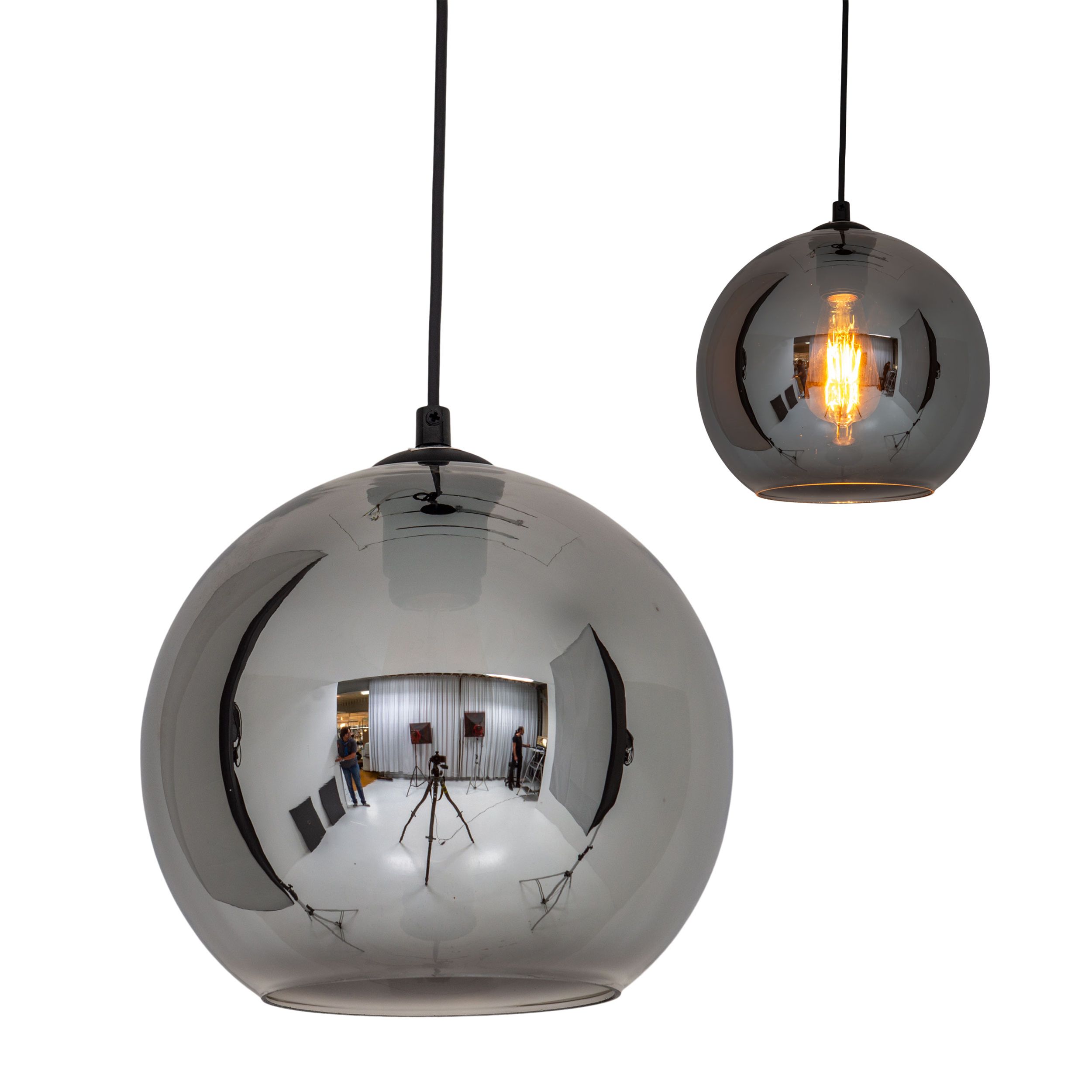 Deux lampes suspendues argentées avec une forme de verre ronde. Une lampe est allumée. Fond blanc.