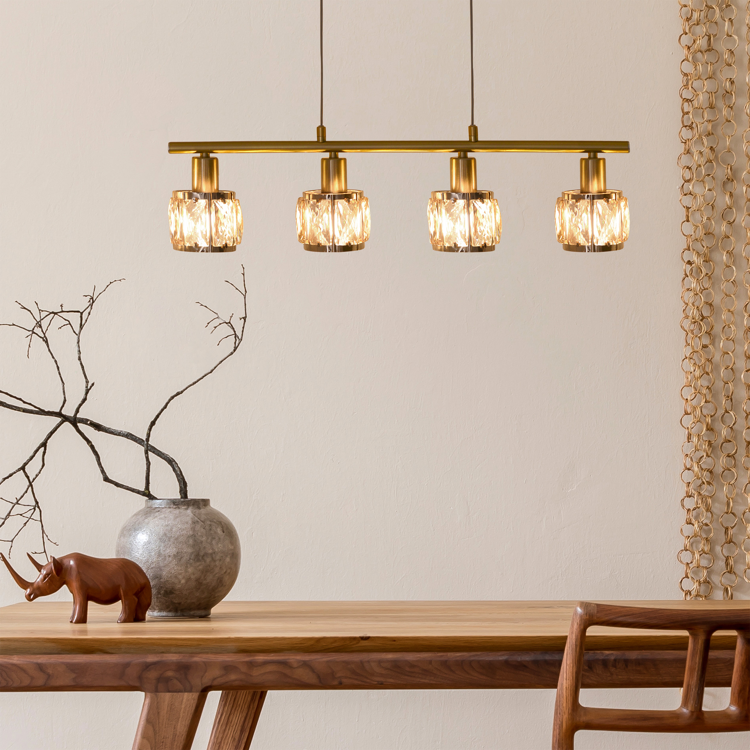 Esszimmer mit Holztisch und Kronleuchter mit Kristalllampen. Beige Wand.