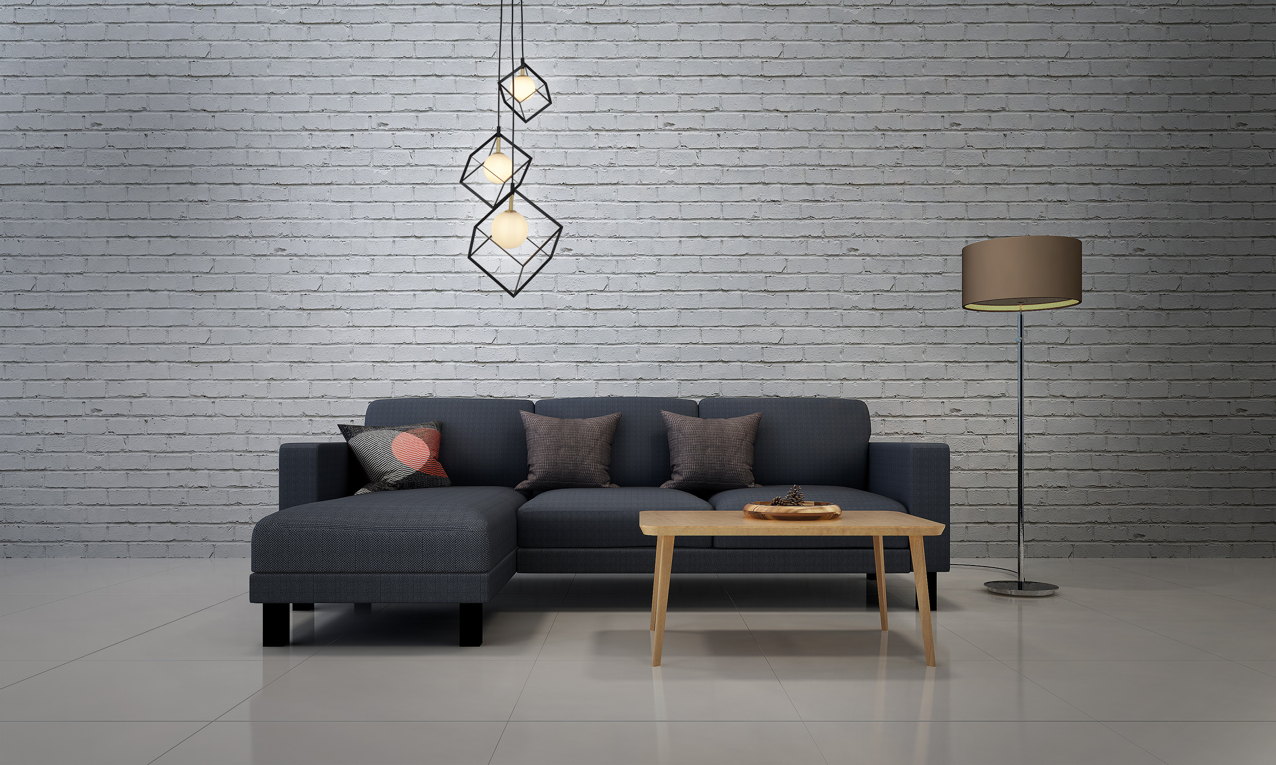 Ein Wohnzimmer mit grauem Sofa, Couchtisch und Lampe. Weiße Backsteinmauer.