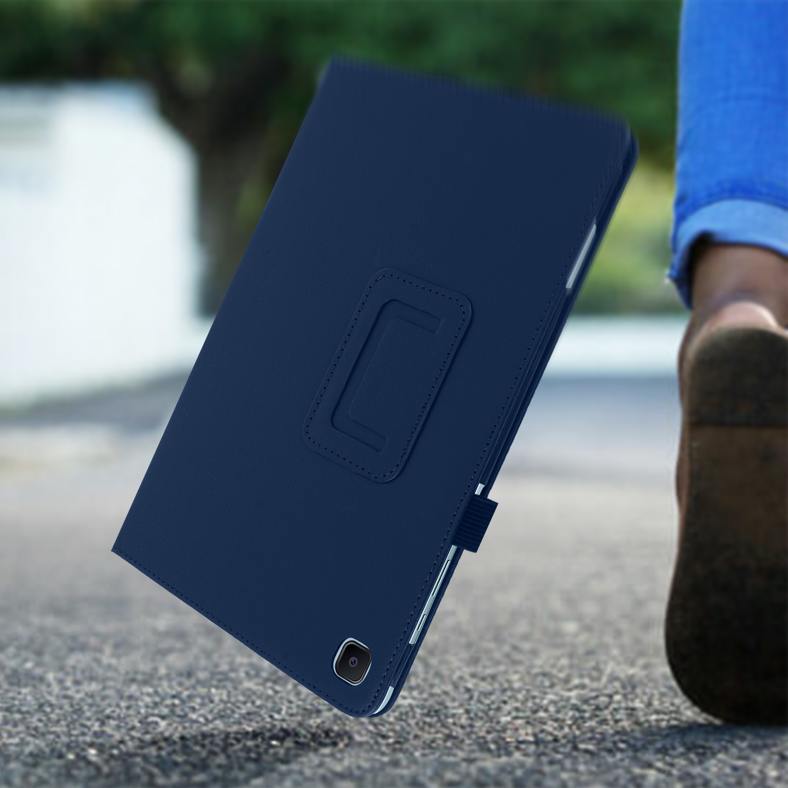 Custodia per tablet blu navy su una superficie. Le gambe e la scarpa di una persona sono visibili.